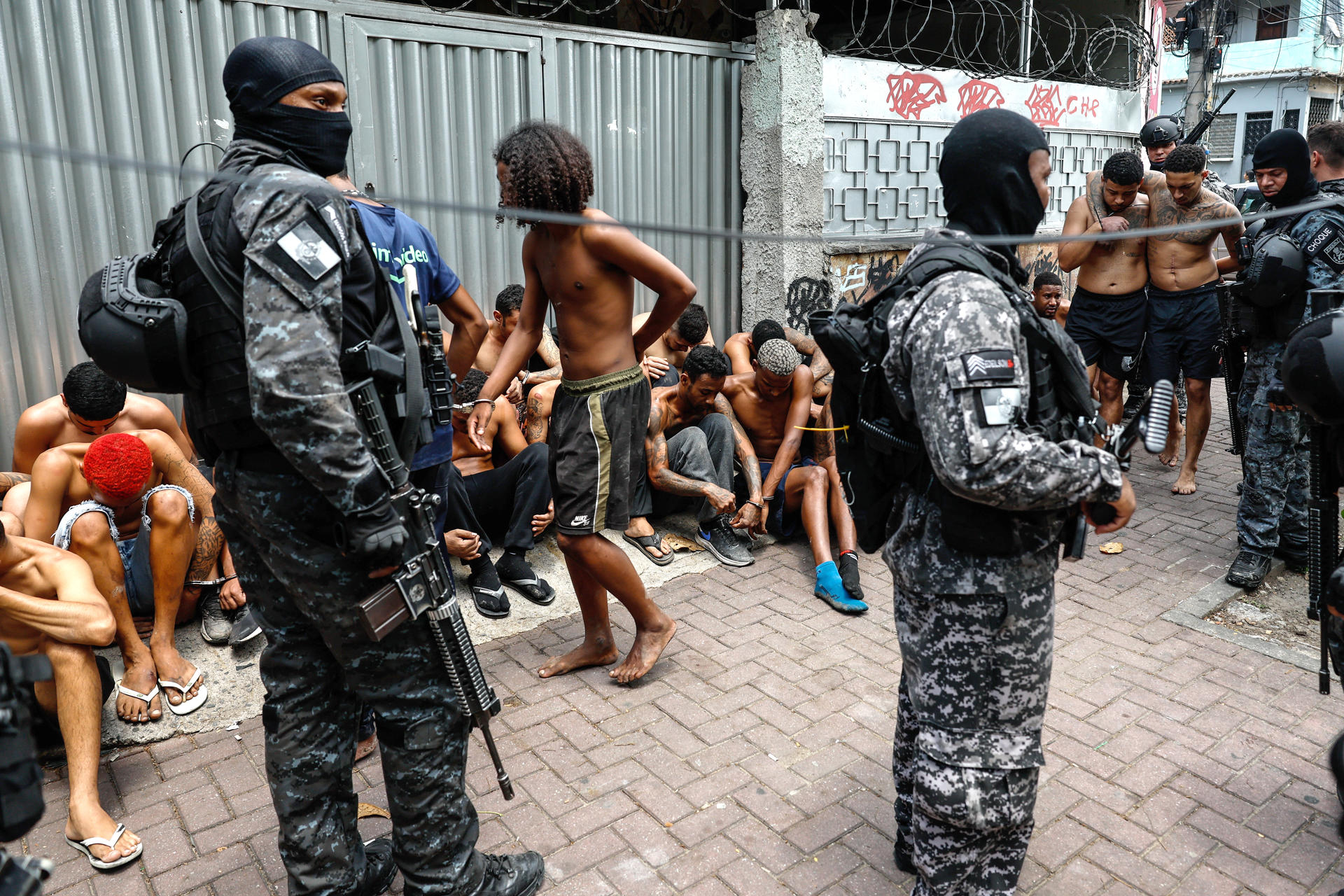 AME2687. RÍO DE JANEIRO (BRASIL), 28/10/2025.- Integrantes de la Policía de Río de Janeiro custodian a un grupo de personas durante un operativo este martes, en Río de Janeiro (Brasil). Al menos veinte personas murieron y medio centenar fueron detenidas en medio de una gran operación policial contra el Comando Vermelho, una de las más poderosas bandas del crimen organizado de Río de Janeiro.EFE/ Antonio Lacerda
