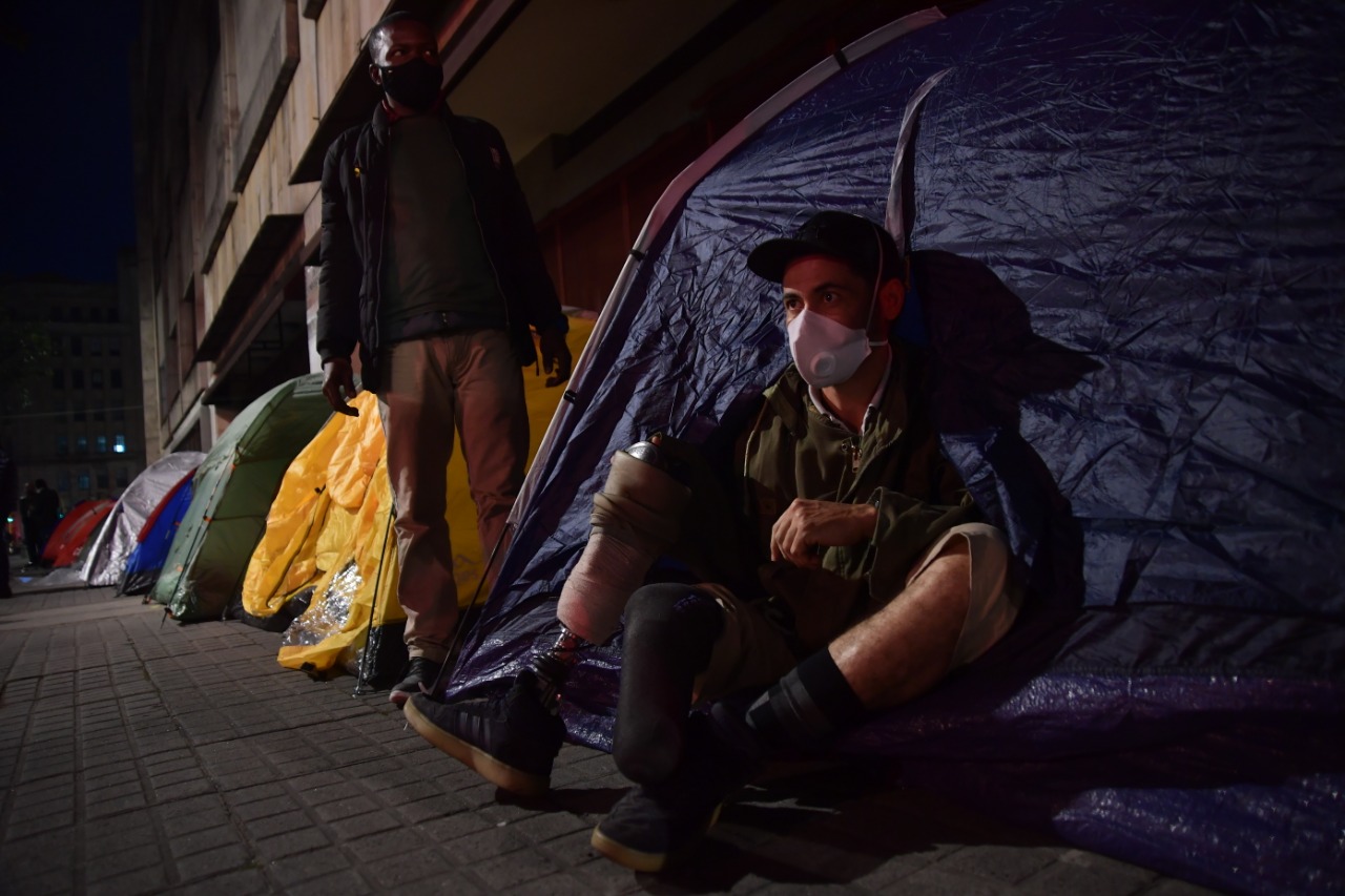 Foto de un soldado con prótesis en una de sus piernas, sentado en el piso de una carpa.