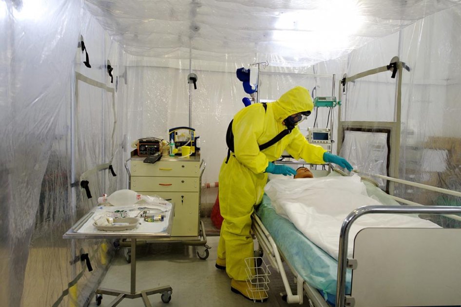 Personal militar viste con trajes especiales mientras trabajan en la simulación de un caso de enfermo de un virus contagioso en el centro de Defensa Biológica en Techonin cerca de Jablone Nad Orlici en República Checa.
