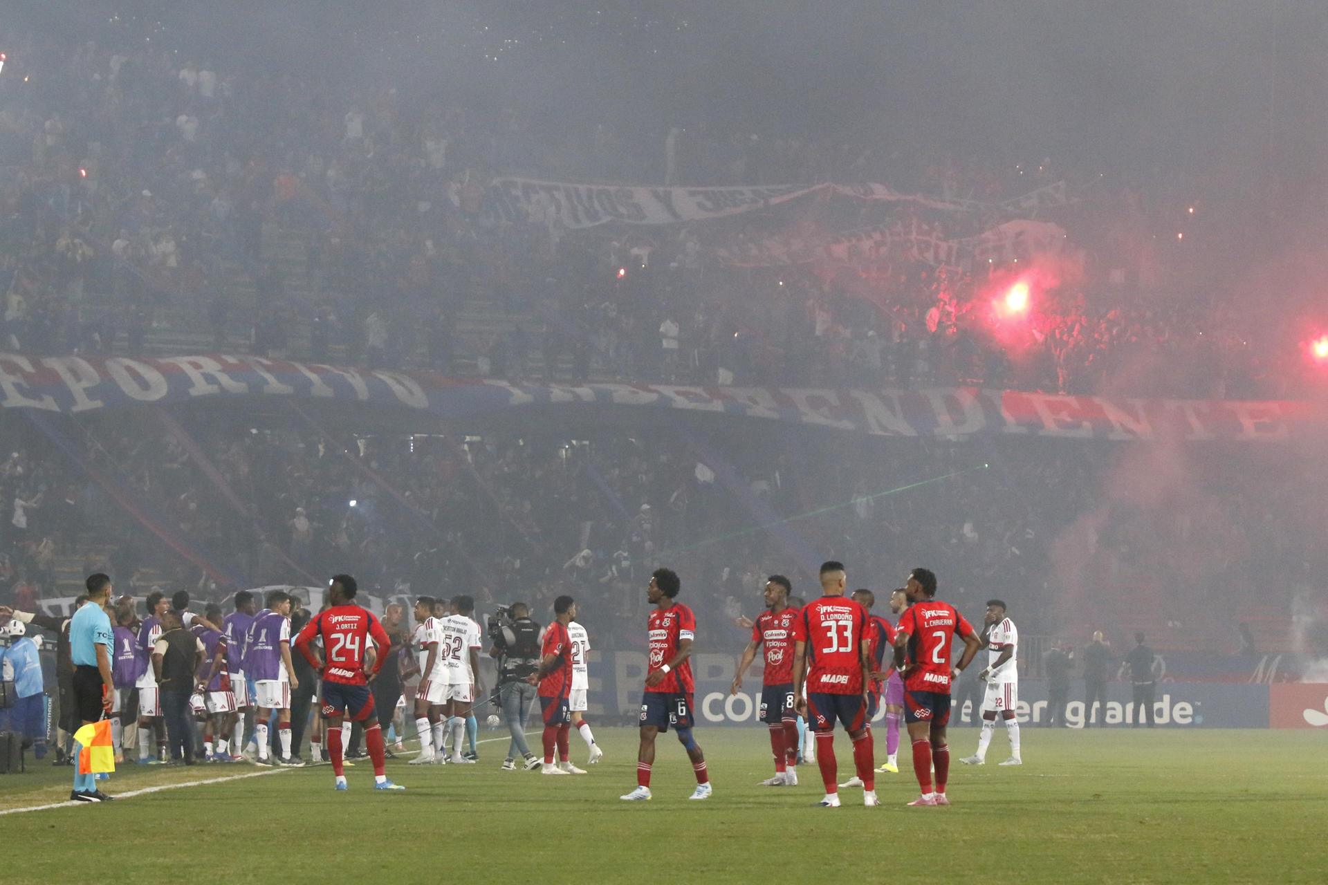 AMDEP5050. MEDELLÍN (COLOMBIA), 07/05/2026.- Jugadores de Medellín y Flamengo esperan para reanudar el partido de la fase de grupos de la Copa Libertadores entre Independiente Medellín y Flamengo este jueves, en el Estadio Atanasio Girardot en Medellín (Colombia). Aficionados del club colombiano, que protestan por el mal momento del equipo, eliminado el domingo pasado de la liga local, lanzaron pirotecnia desde la tribuna norte, lo que originó una humareda que causó poca visibilidad en la cancha; arrojaron objetos, e intentaron ingresar al terreno de juego. EFE/ STR
