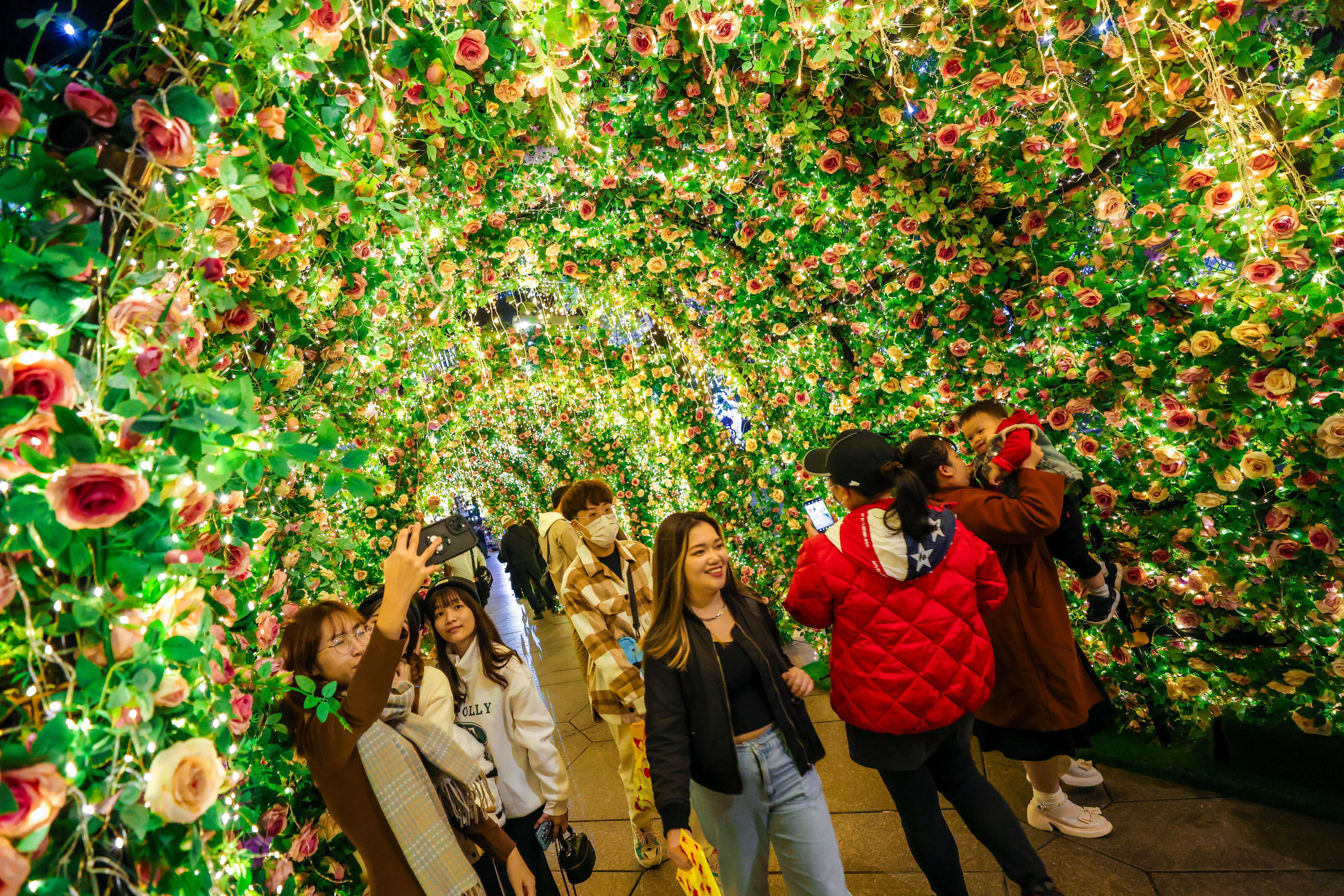 New Taipei City (Taiwan), 18/12/2023.- People pose for photographs under Christmas Lights decorations in Taipei, Taiwan, 18 December 2023. Christmas is not an official holiday in Taiwan, but many young Taiwanese celebrate it by having Christmas dinner or giving gifts to friends. EFE/EPA/RITCHIE B. TONGO