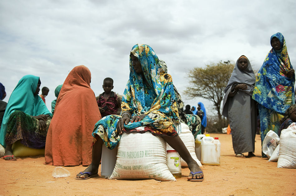 Mujeres somalíes que se sientan con sus raciones de alimentos de socorro después de recibirlas durante un ejercicio de distribución en un campo de desplazados en Dollow.