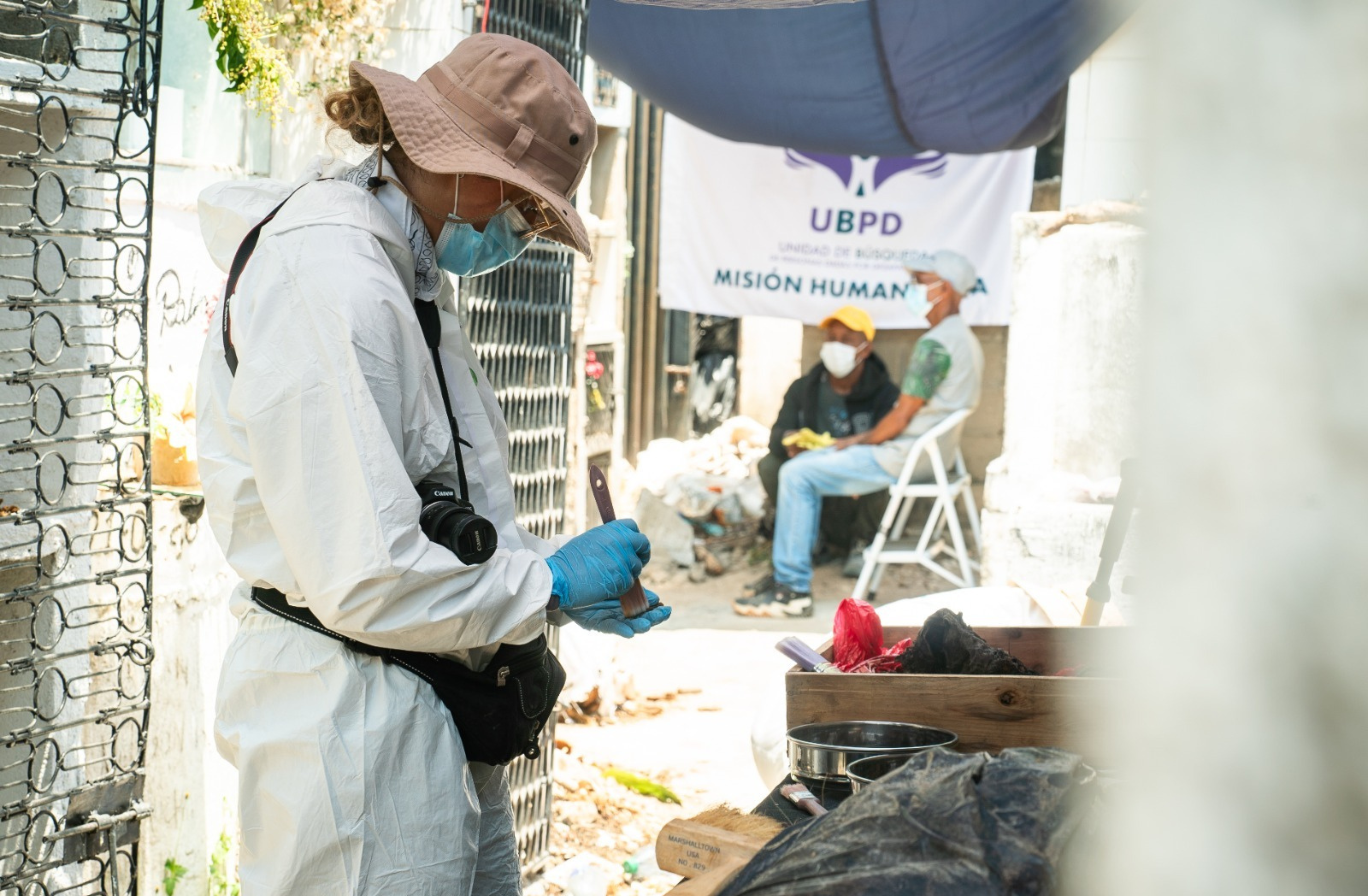 Las antropólogas y los forenses de la UBPD disponen dos mesas en un pasillo del cementerio para la fase de prospección y recuperación de dos cuerpos inhumados en una bóveda del cementerio San Rafael.