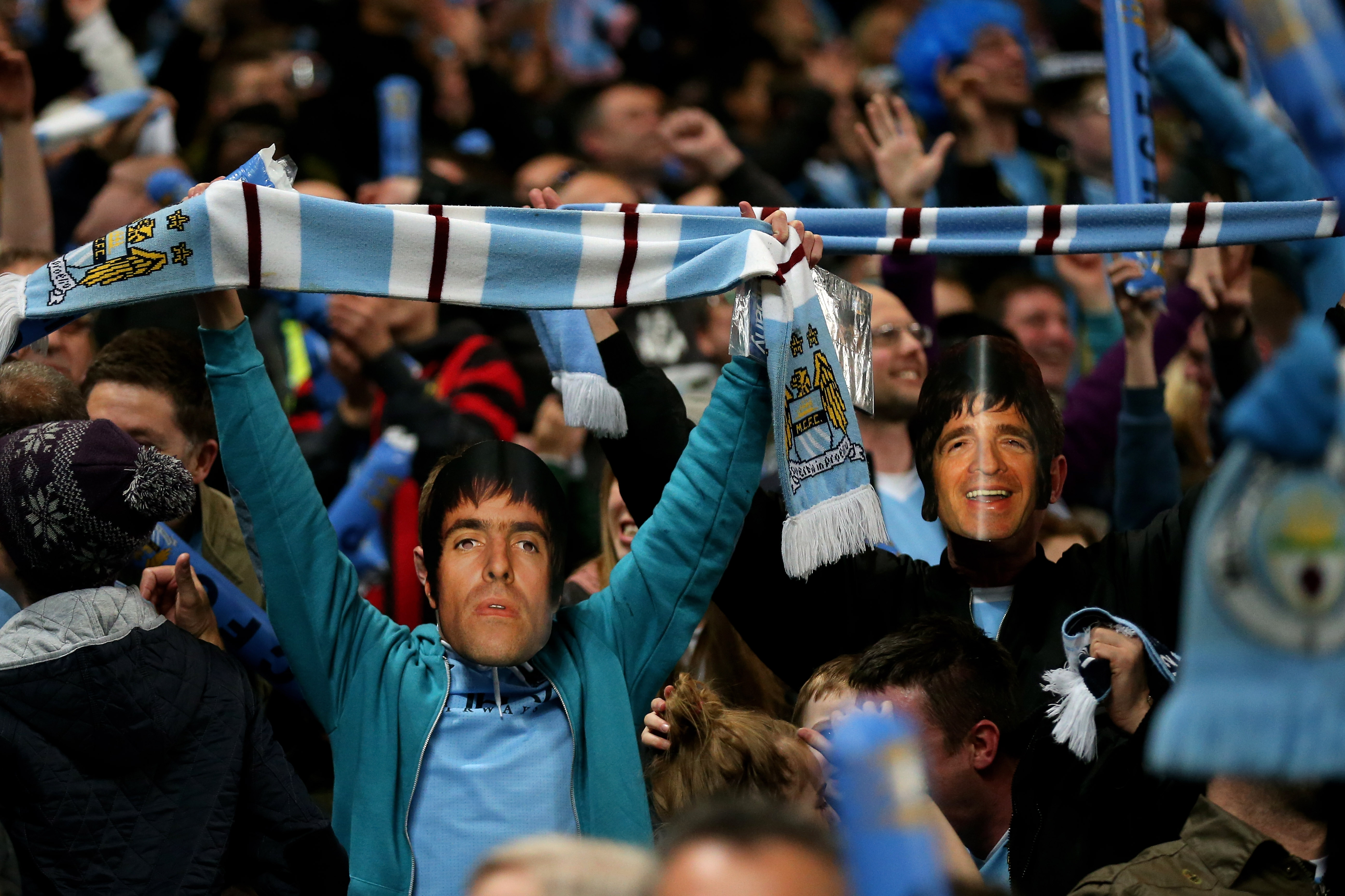 Los fanáticos del Manchester City con máscaras de los hermanos Gallagher celebran al final del partido de la Barclays Premier League entre el Manchester City y el Manchester United en el Etihad Stadium el 30 de abril de 2012 en Manchester, Inglaterra.