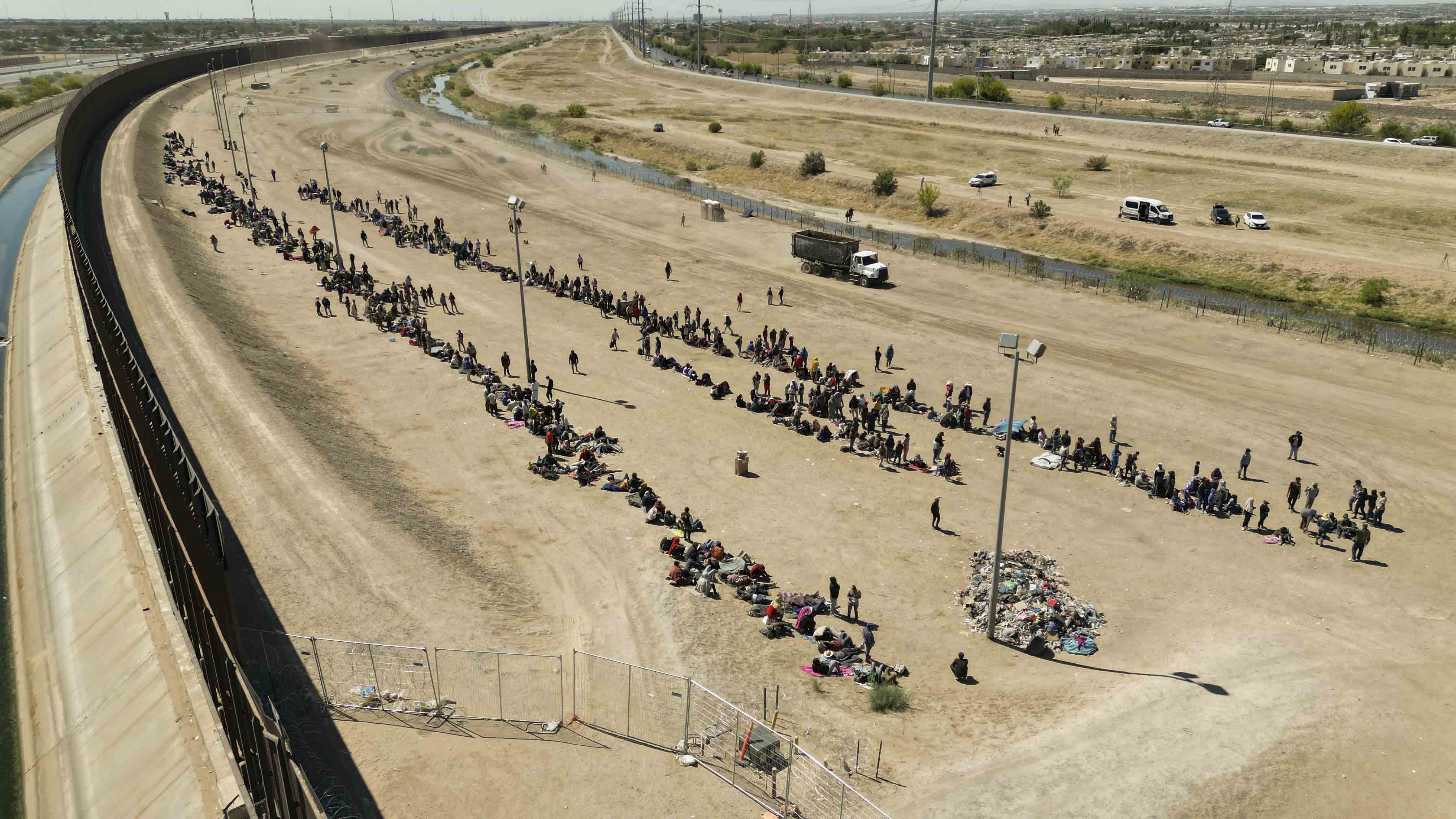 AME8785. EL PASO (ESTADOS UNIDOS), 11/05/2023.- Fotografía aérea muestra hoy a cientos de migrantes mientras esperan junto al muro fronterizo en El Paso, Texas (EE.UU). La Patrulla fronteriza de Estados Unidos ha detenido a 2.500 migrantes en las últimas 48 horas y espera concluir su procesamiento y traslado a sus instalaciones en las próximas 24 horas, anunció este jueves el jefe de la Patrulla Fronteriza a nivel nacional, Raúl Ortiz. EFE/ Jonathan Fernández