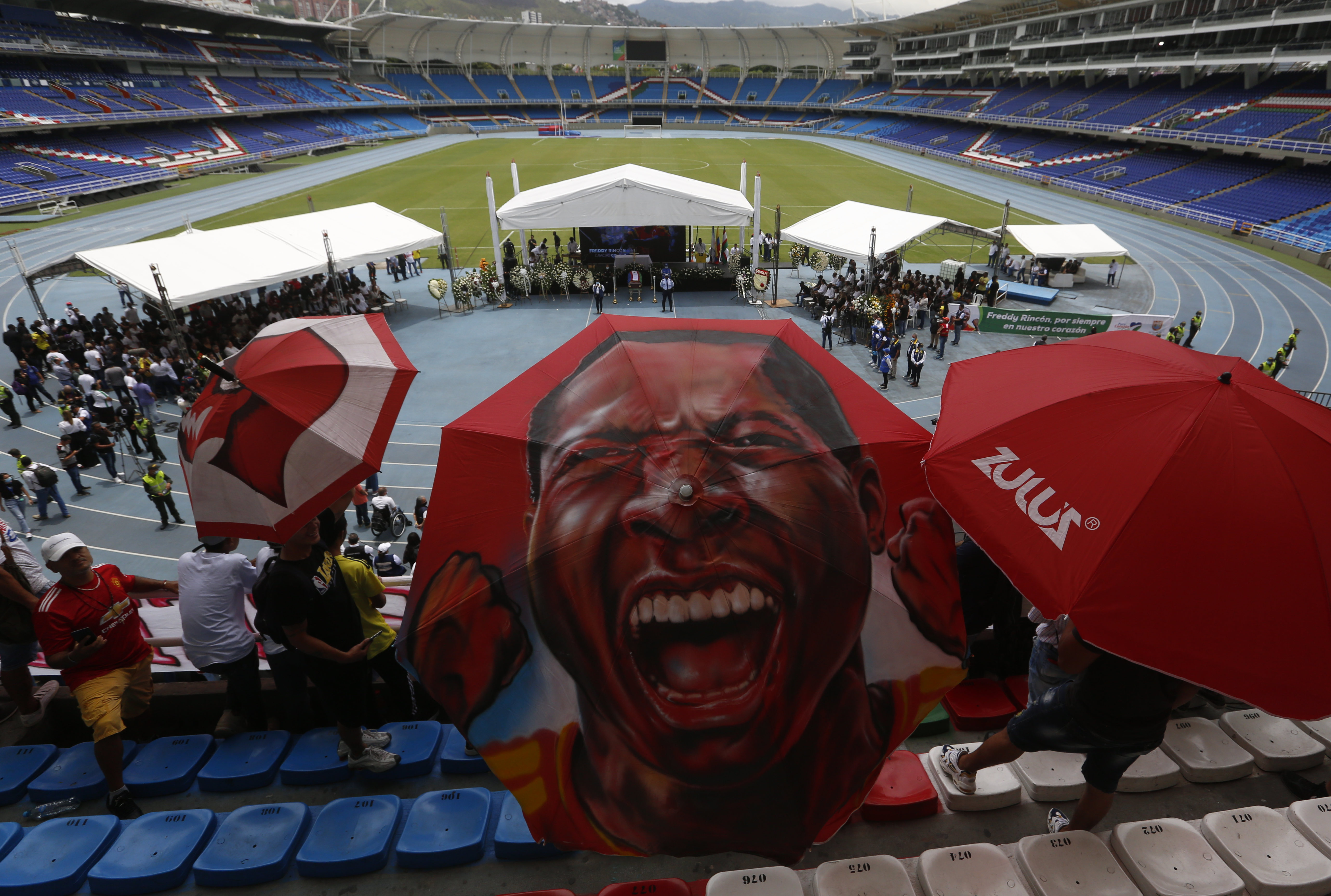 AME1783. CALI (COLOMBIA), 16/04/2022.- Un aficionado usa un paraguas con la imagen del exfutbolista colombiano Freddy Rincón hoy, durante un homenaje en el estadio Pascual Guerrero en Cali (Colombia). Rincón falleció el miércoles en la noche luego de sufrir un accidente automovilístico. EFE/ Ernesto Guzmán Jr