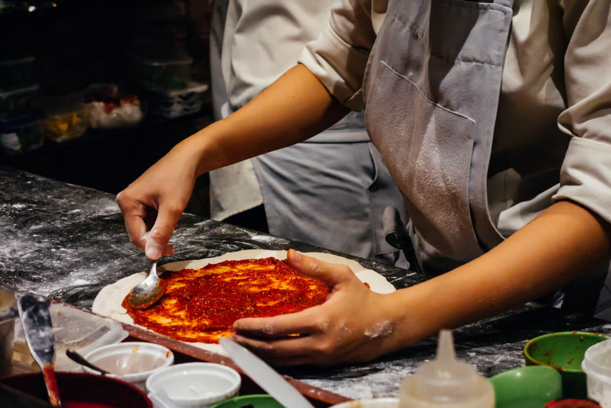 En Italia existen muchos talleres para que los viajeros aprendan a preparar pizza.