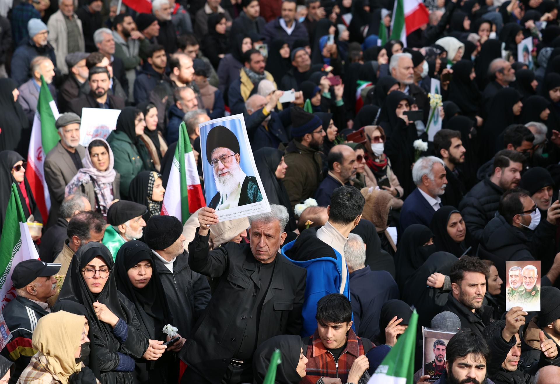 Tehran (Iran (Islamic Republic Of)), 14/01/2026.- Mourners hold national flags and portraits of Iranian Supreme Leader Ayatollah Ali Khamenei during a funeral ceremony for security personnel killed during anti-government protests, in Tehran, Iran, 14 January 2026. The ceremony takes place as Iran remains under a nationwide internet blackout that began on 08 January, amid an intensifying wave of civil unrest. (Protestas, Teherán) EFE/EPA/ABEDIN TAHERKENAREH

