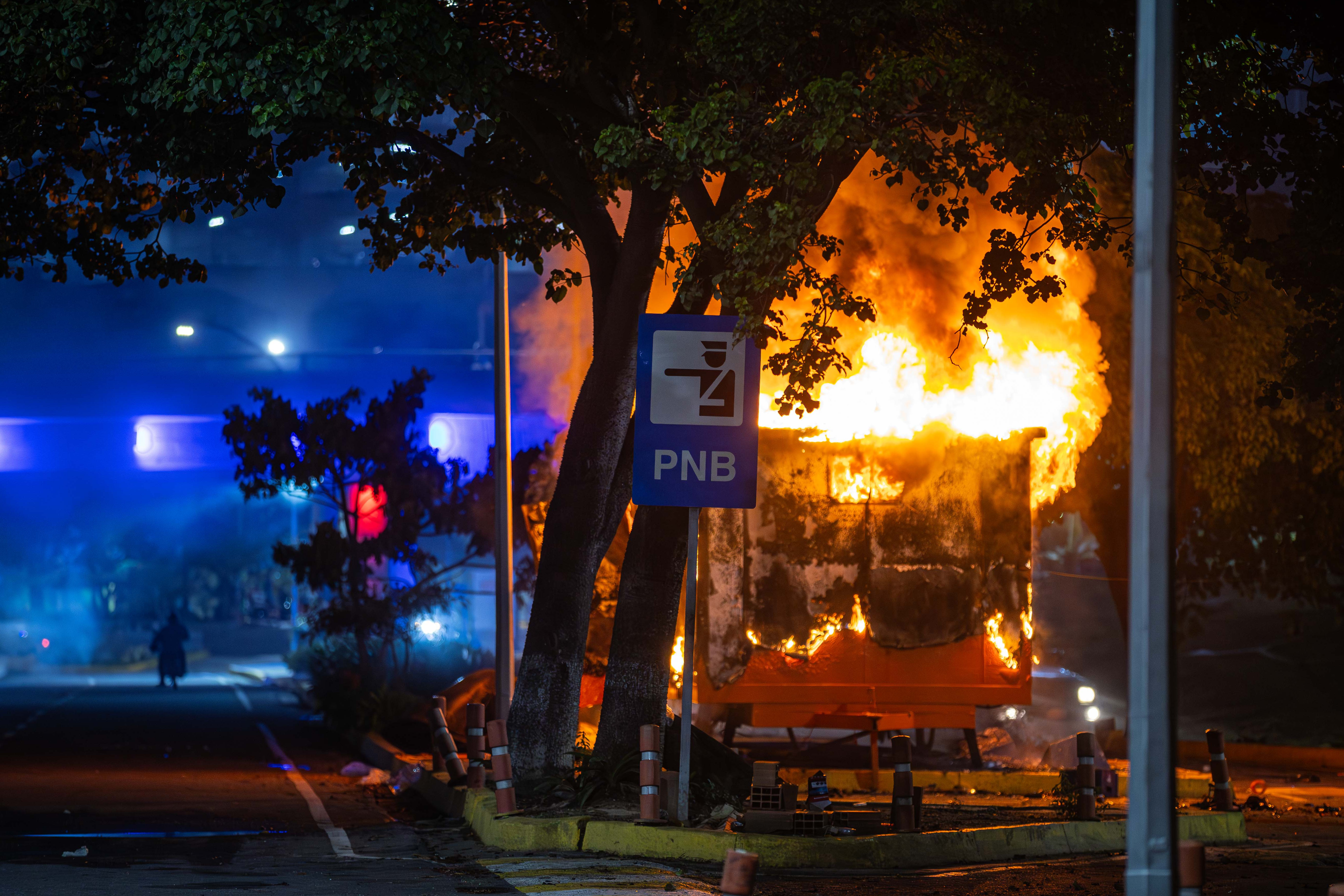AME6327. CARACAS (VENEZUELA), 29/07/2024.- Fotografía de un módulo de la Policía Nacional Bolivariana (PNB) incendiado durante las protestas por los resultados de las elecciones presidenciales este lunes, en la autopista Prados del Este, en Caracas (Venezuela). Miles de ciudadanos han salido para protestar contra los resultados anunciados por el Consejo Nacional Electoral (CNE), que otorga al presidente Maduro el 51,2 % de los votos, un dato cuestionado por la oposición y por buena parte de la comunidad internacional. EFE/ Henry Chirinos