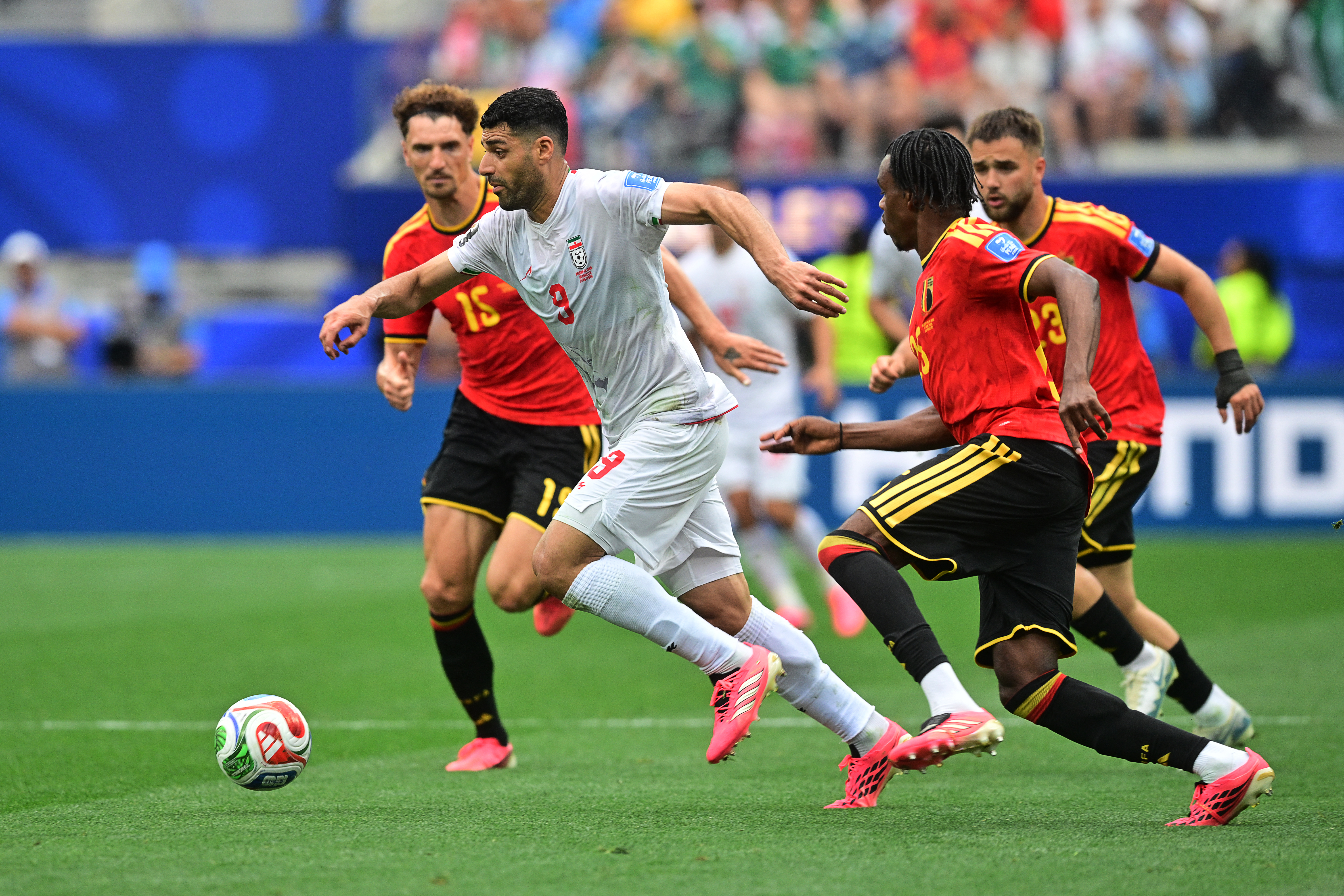 Iran's forward #09 Mehdi Taremi and Belgium's defender #25 Nathan Ngoy fight for the ball during the 2026 World Cup Group G football match between Belgium and Iran at the Los Angeles Stadium in Inglewood on June 21, 2026.  (Photo by Frederic J. Brown / AFP)