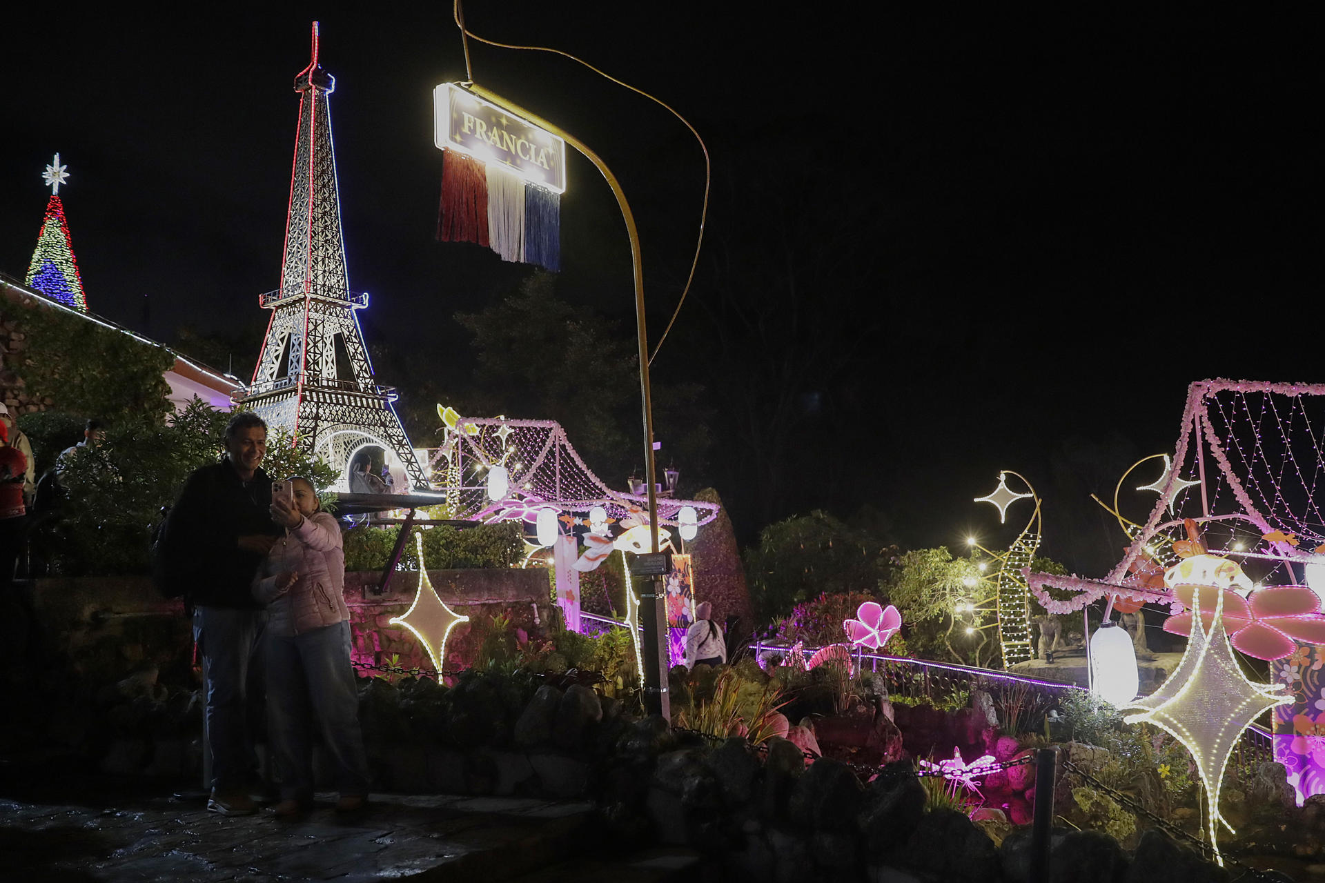 AME9236. BOGOTÁ (COLOMBIA), 18/12/2025.- Fotografía del 16 de diciembre de 2025 que muestra personas recorriendo la iluminación de Navidad en el cerro Monserrate en Bogotá (Colombia). Al caer la noche, cuando el frío y la neblina abrazan los cerros bogotanos, el de Monserrate se transforma en un sendero de luz que viaja por once países y convoca a familias y turistas a celebrar la Navidad bajo la música de las novenas que resuena en la cima de la capital colombiana. EFE/ Carlos Ortega