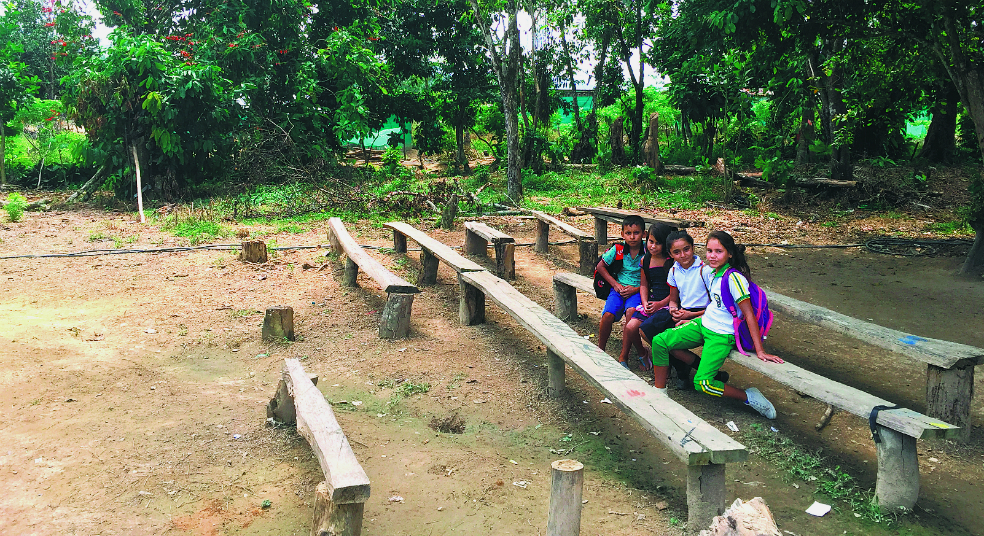 Los niños del 20 de Mayo, un barrio de invasión en el municipio de El Tarra, Norte de Santander, estudian a la intemperie en un salón improvisado por la comunidad. / / Marcela Olarte