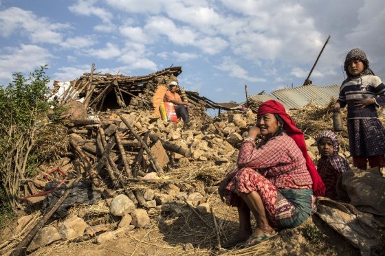 Ciudadanos de Nepal sobre los escombros de grandes construcciones en Katmandú. / AFP