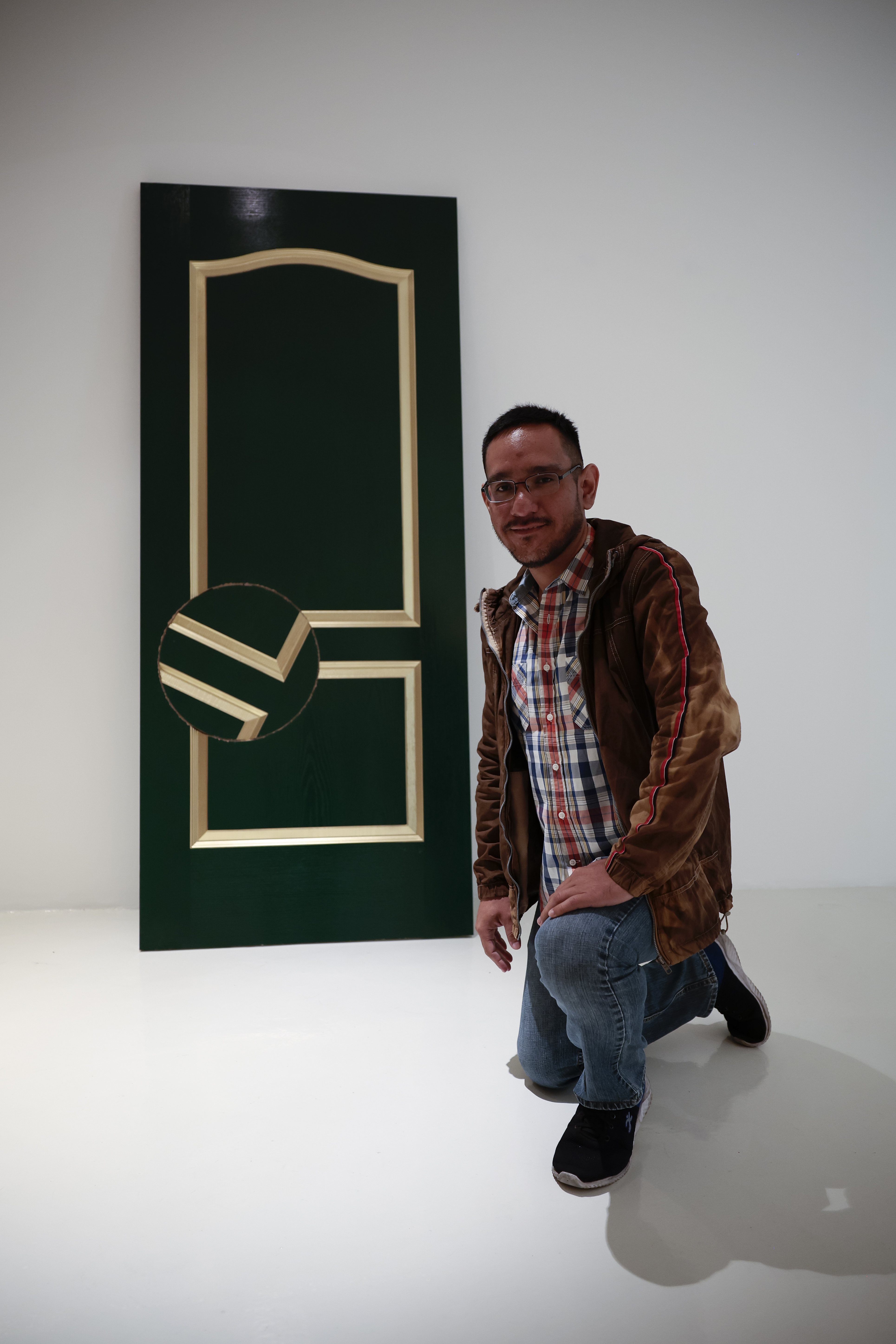MEX1881. CIUDAD DE MÉXICO (MÉXICO), 15/11/2023.- El migrante peruano Andrés, posa junto a la obra inspirada en su vida titulada "Salvoconducto", de la artista mexicana Bárbara Lázara el 14 de noviembre de 2023, en la Galería Hilario Galguera en Ciudad de México (México). La galería Hilario Galguera, en la Ciudad de México, acoge desde este miércoles hasta el 13 de enero de 2024 "Puertas de Esperanza", una exposición cuyo eje narrativo son las historias de siete personas del colectivo LGBTI supervivientes a diferentes violencias. EFE/José Méndez