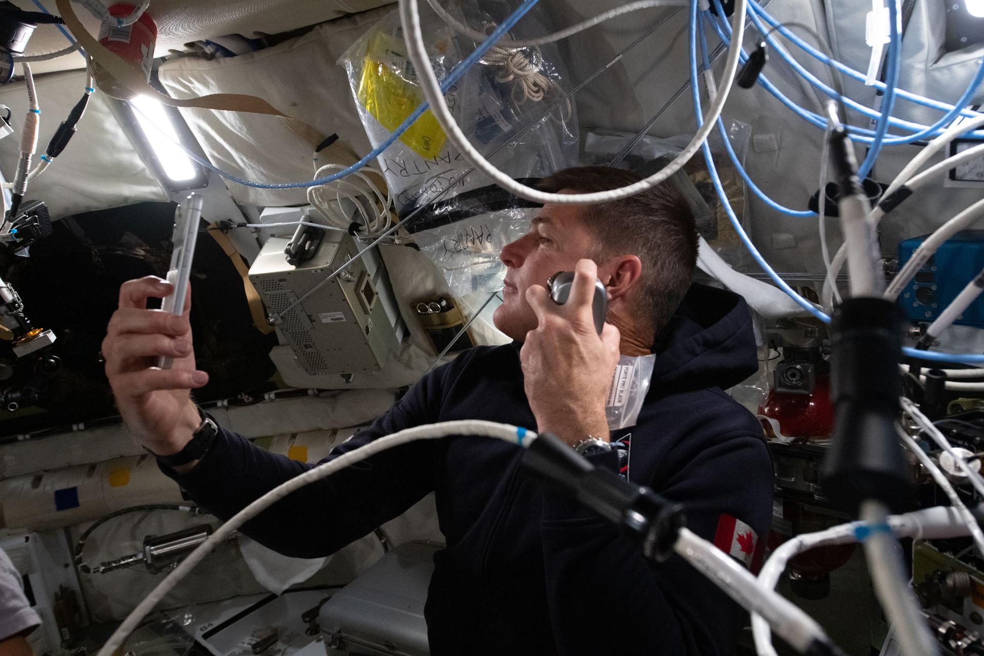 El astronauta canadiense Jeremy Hansen, mientras se afeita dentro de la nave espacial Orion durante el quinto día de vuelo.
