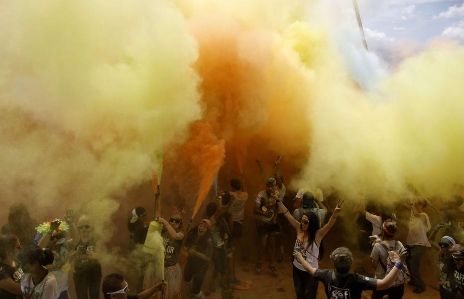 Paisas corriendo en una nube de colores