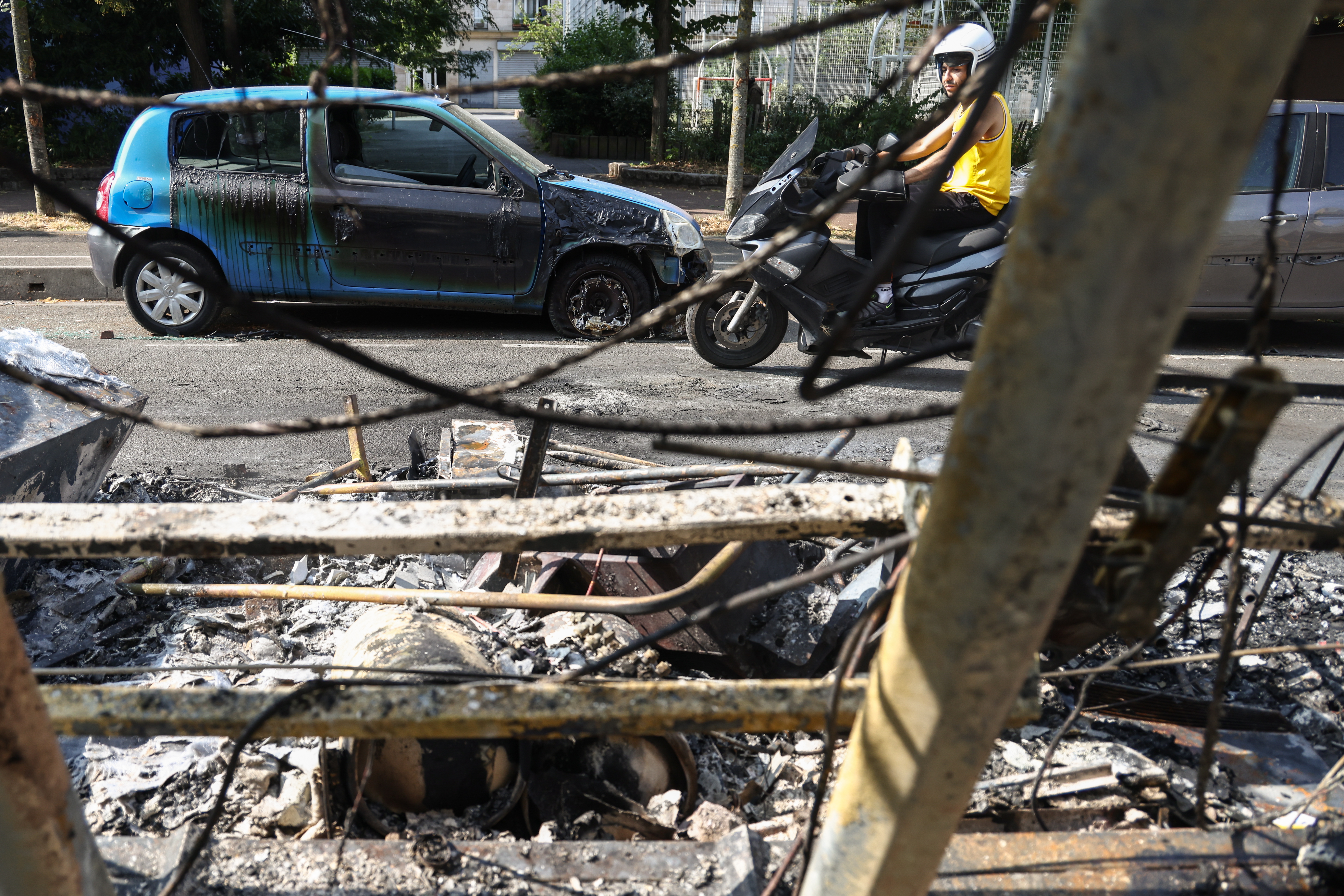 Nanterre (France), 28/06/2023.- A motorcyclist passes burnt out cars and debris on avenue Pablo Picasso following a night of civil unrest, in Nanterre, near Paris, France, 28 June 2023. The violence broke out after police fatally shot a 17-year-old during a traffic stop in Nanterre. According to the French interior minister, 31 people were arrested with 2,000 officers being deployed to prevent further violence. (Disturbios, Francia) EFE/EPA/Mohammed Badra