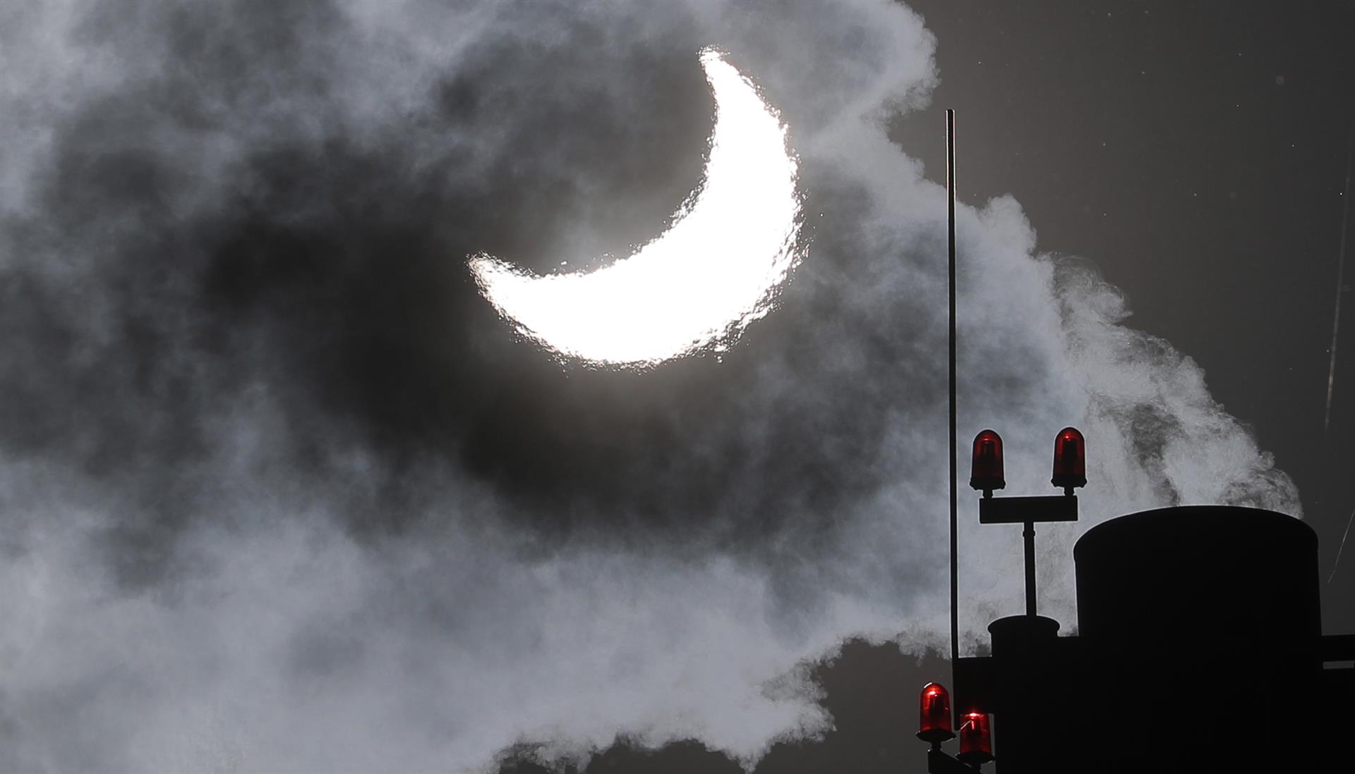 De una sala de calderas de gas sale humo durante el eclipse solar parcial en Moscú. Desde Rusia el sol apareció eclipsado en un 70 por ciento.