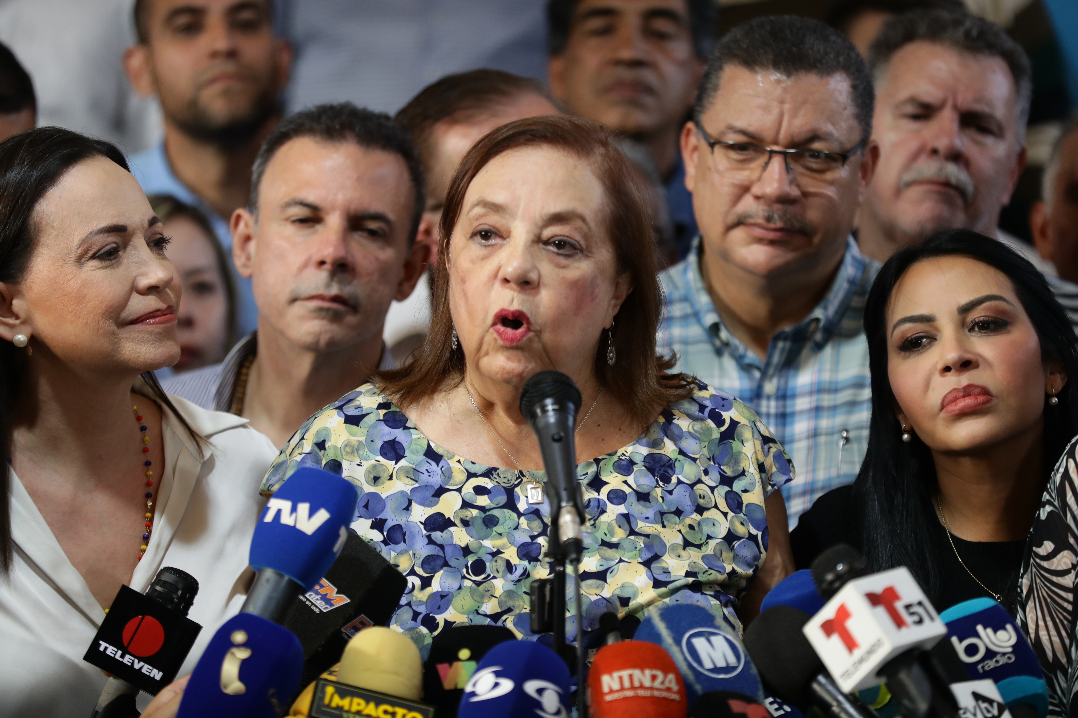 AME1083. CARACAS (VENEZUELA), 22/03/2024.- La historiadora Corina Yoris (c) habla luego de ser presentada como la candidata para las elecciones presidenciales del próximo 28 de julio, en vista de la inhabilitación que impide competir a la líder antichavista María Corina Machado (izq.), durante una rueda de prensa este viernes, en Caracas (Venezuela). En declaraciones a la prensa, Machado aseguró que la decisión "surgió del seno de la discusión de las fuerzas unitarias" y forma parte de un mecanismo acordado para hacer "frente a este obstáculo", en referencia a su inhabilitación, ratificada en enero por el Tribunal Supremo de Justicia (TSJ), una sanción a la calificó como "un acto írrito, totalmente inconstitucional y cobarde". EFE/ Rayner Peña R.