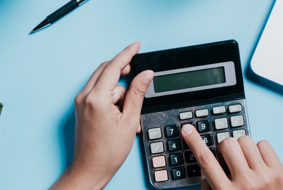 Un señor hace cuentas en una calculadora.