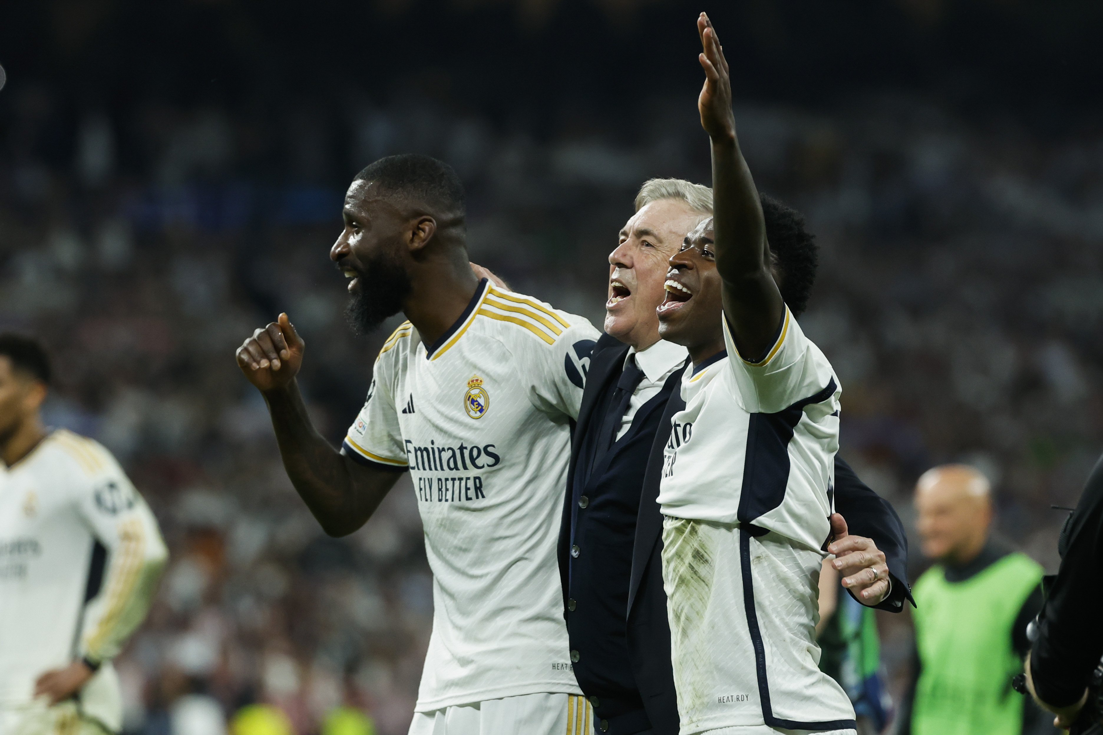 MADRID, 08/05/2024.- (i-d) Antonio Rudiger, Carlo Ancelotti y Vinicius Jr., todos del Real Madrid, celebran la victoria tras el partido de vuelta de las semifinales de la Liga de Campeones que Real Madrid y Bayern de Múnich disputaron hoy miércoles en el estadio Santiago Bernabéu, en Madrid. EFE/JUANJO MARTIN