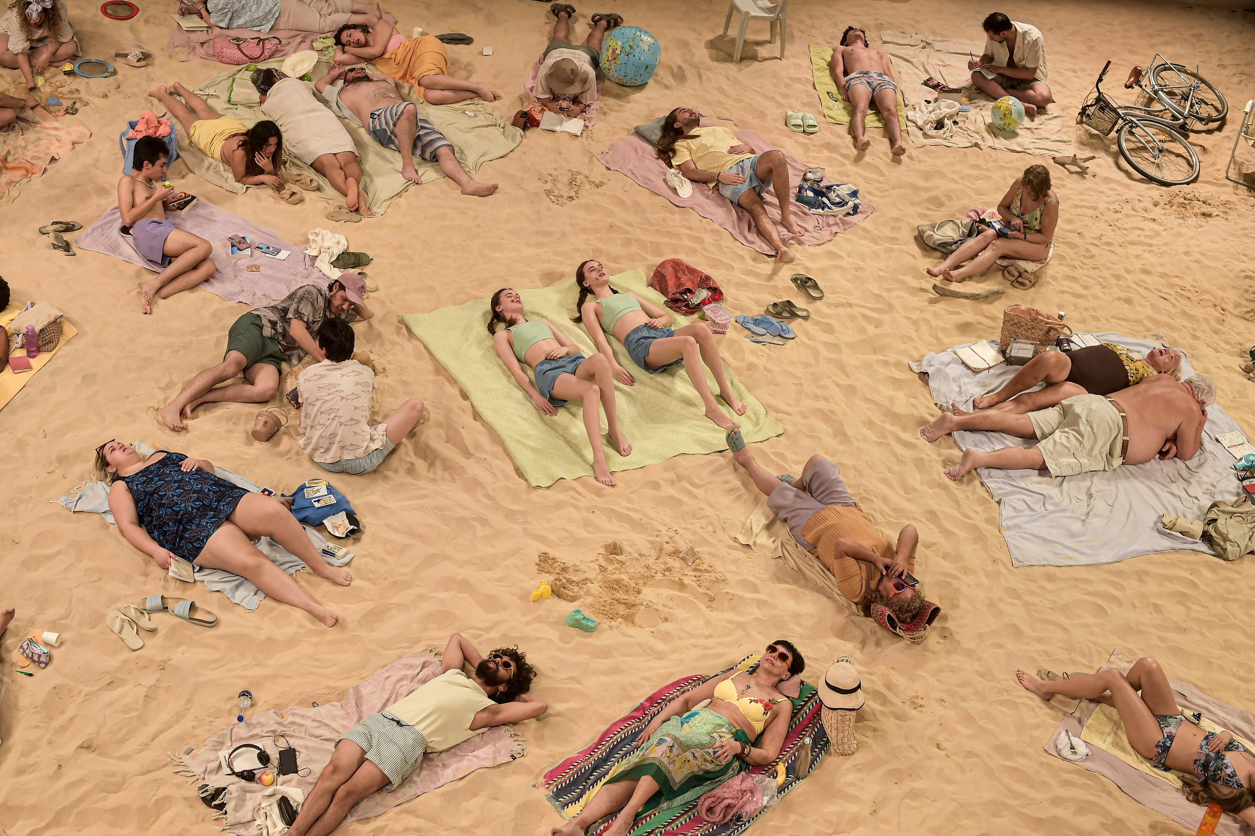La obra, dirigida por las lituanas Rugilė Barzdžiukaitė, Vaiva Grainytė y Lina Lapelytė, reúne a veinte participantes en el performance/instalación que emulan un día en la playa.