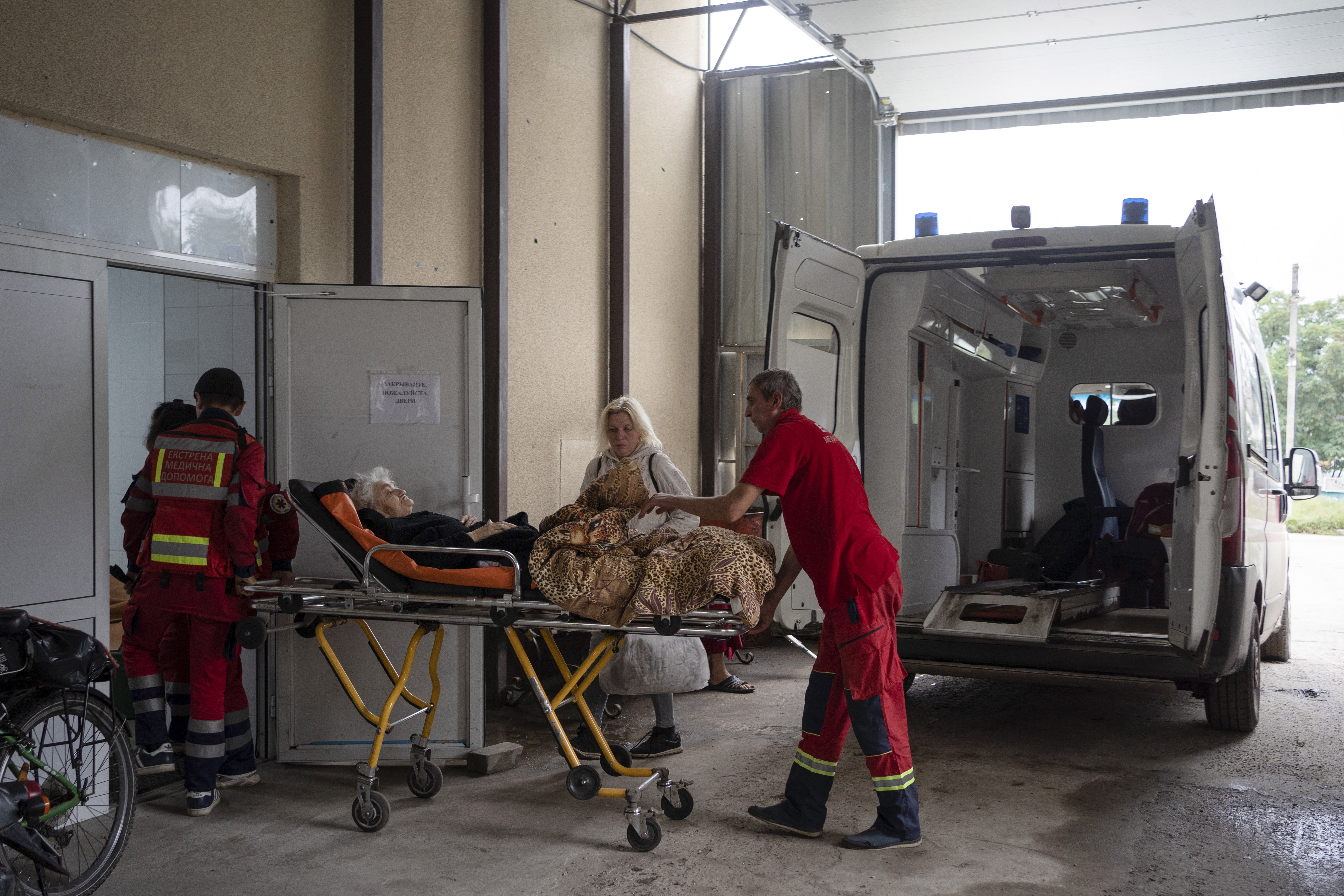 Trabajadores de ambulancia llevan a un residente local a un hospital en la ciudad recuperada de Izyum, Ucrania.