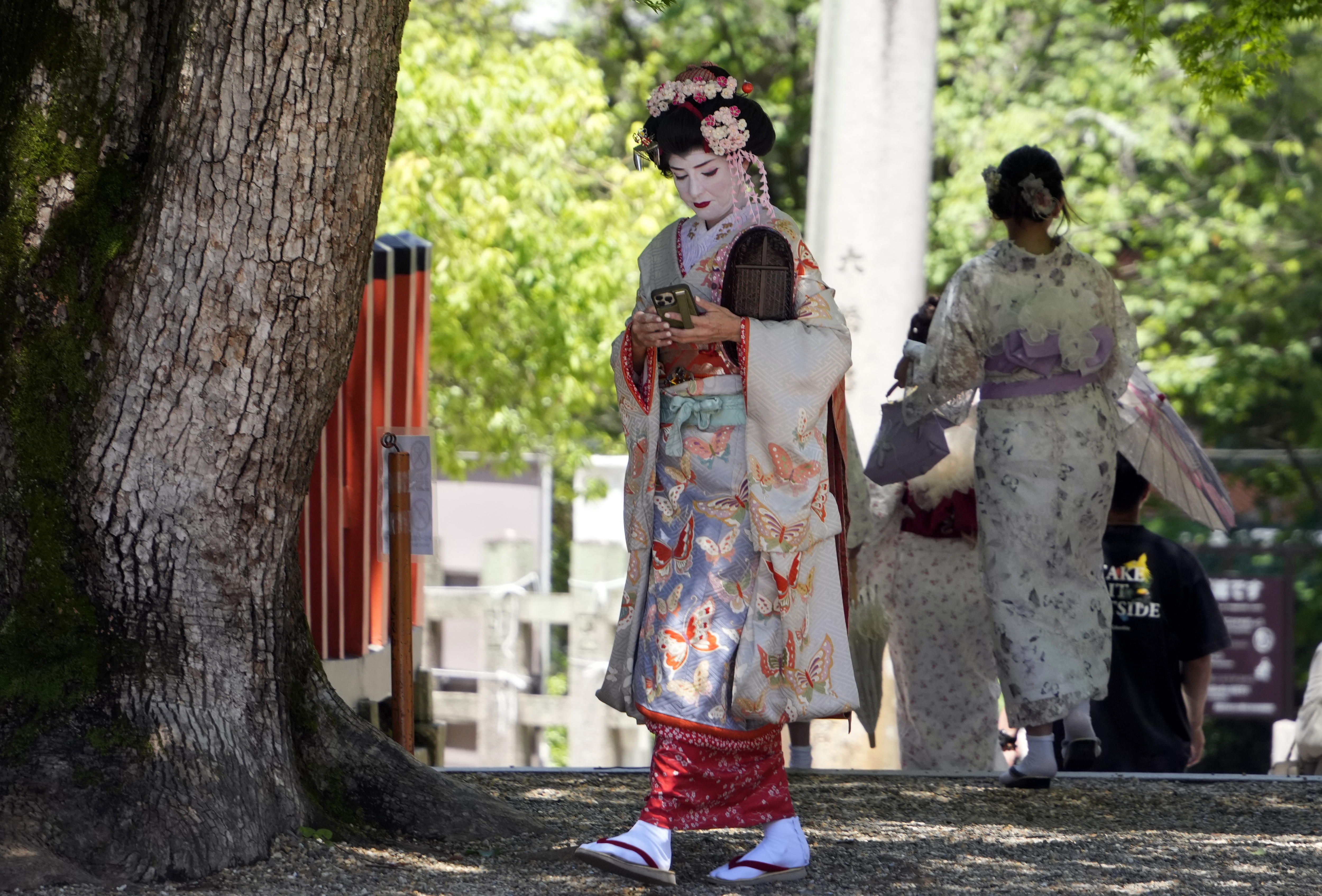 Kyoto (Japan), 29/05/2024.- A foreign tourist dressed as a maiko visits the Yasaka shrine near Gion district in Kyoto, western Japan, 29 May 2024. Gion, the famous Maiko and Geisha district of Kyoto, has begun to apply access restrictions on its streets in the face of overtourism, illustrating Japan's difficulties in dealing with the record number of foreign travelers that the country has been receiving in recent months.  (Japón) EFE/EPA/FRANCK ROBICHON