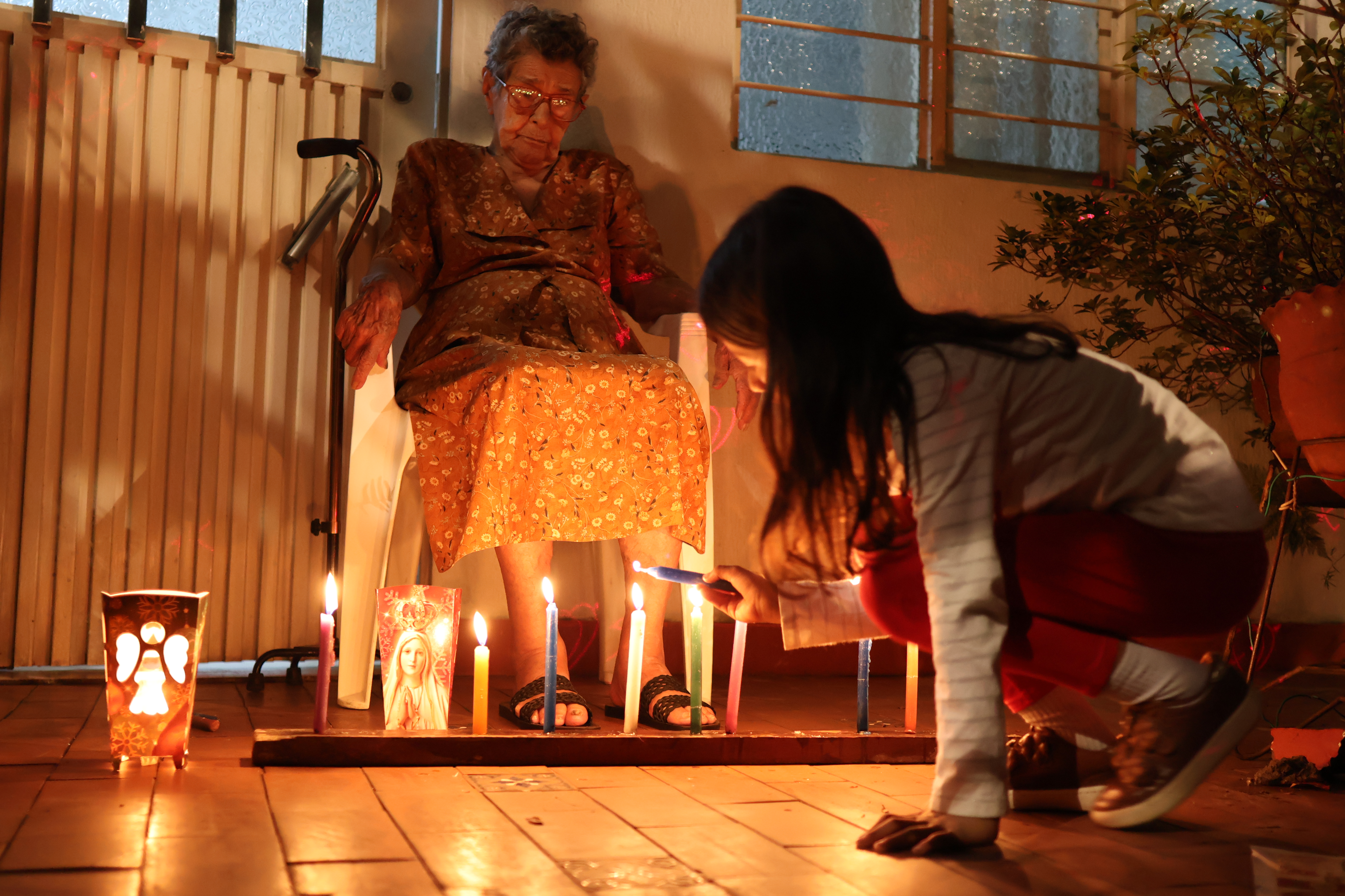 AME2779. CALI (COLOMBIA), 07/12/2023.- Una familia enciende velas en el tradicional día de velitas, costumbre colombiana que celebra el día de la Inmaculada Concepción y marca el inicio de la Navidad, hoy en Cali (Colombia). EFE/Ernesto Guzmán