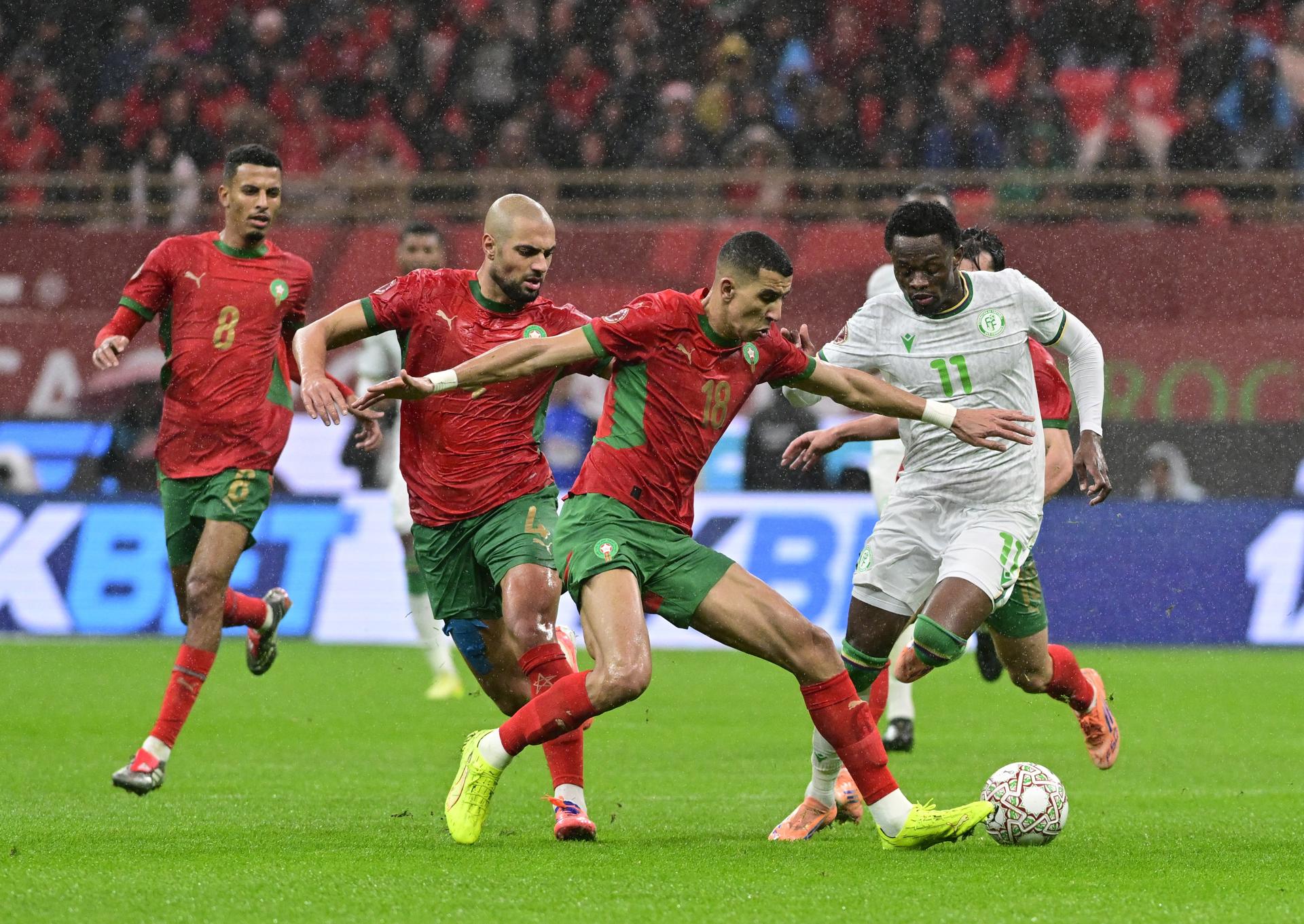 Rabat (Morocco), 21/12/2025.- Jawad El Yamiq (C) of Morocco in action against Rafiki Said Ahamada (R) of the Comoros during the CAF Africa Cup of Nations 2025 soccer match between Morocco and the Comoros in Rabat, Morocco, 21 December 2025. (Comores, Marruecos) EFE/EPA/JALAL MORCHIDI