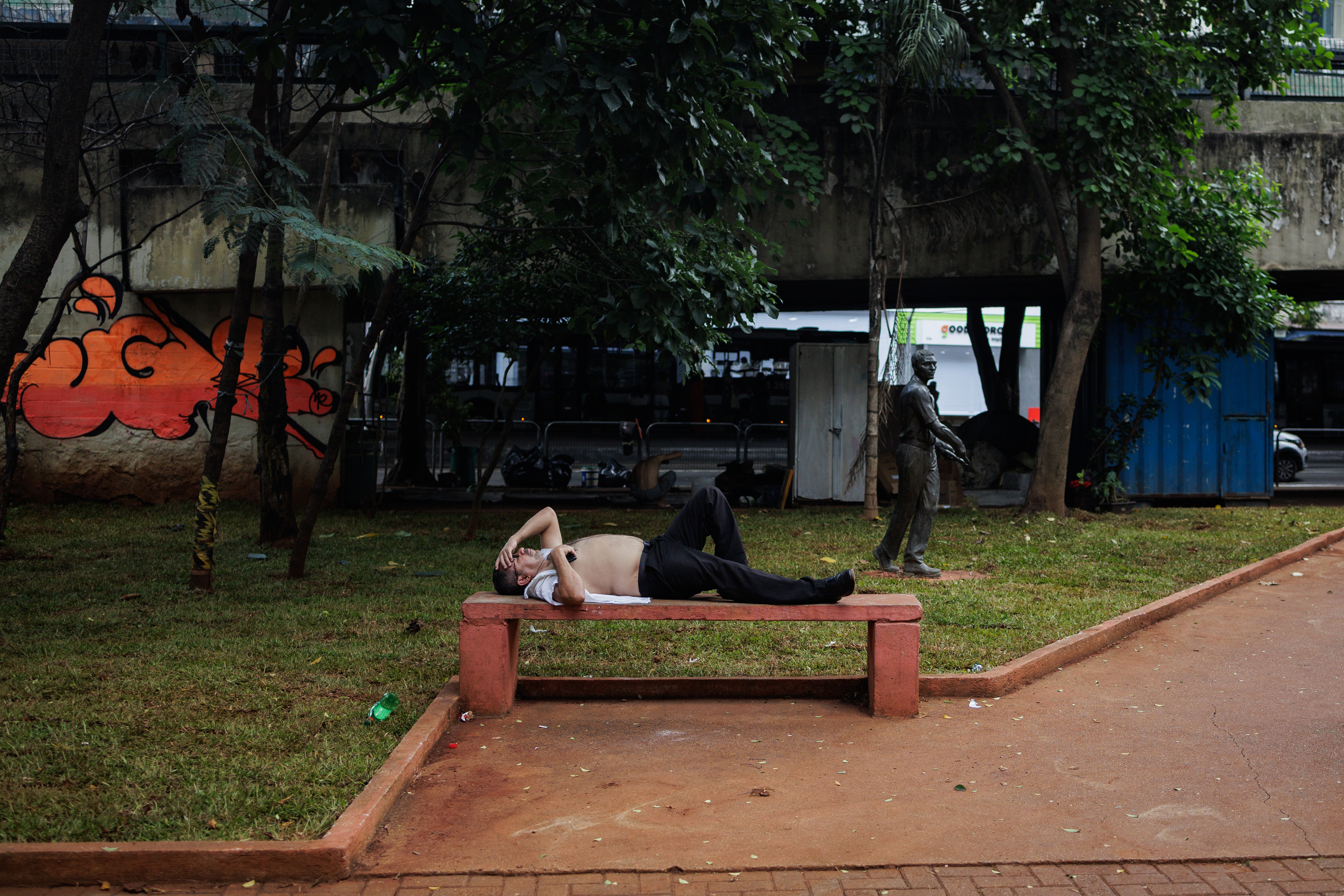 AME8874. SAO PAULO (BRASIL), 15/03/2024.- Un hombre descansa de la fuerte ola de calor en un banco este viernes, en la ciudad de São Paulo (Brasil). EFE/ Isaac Fontana
