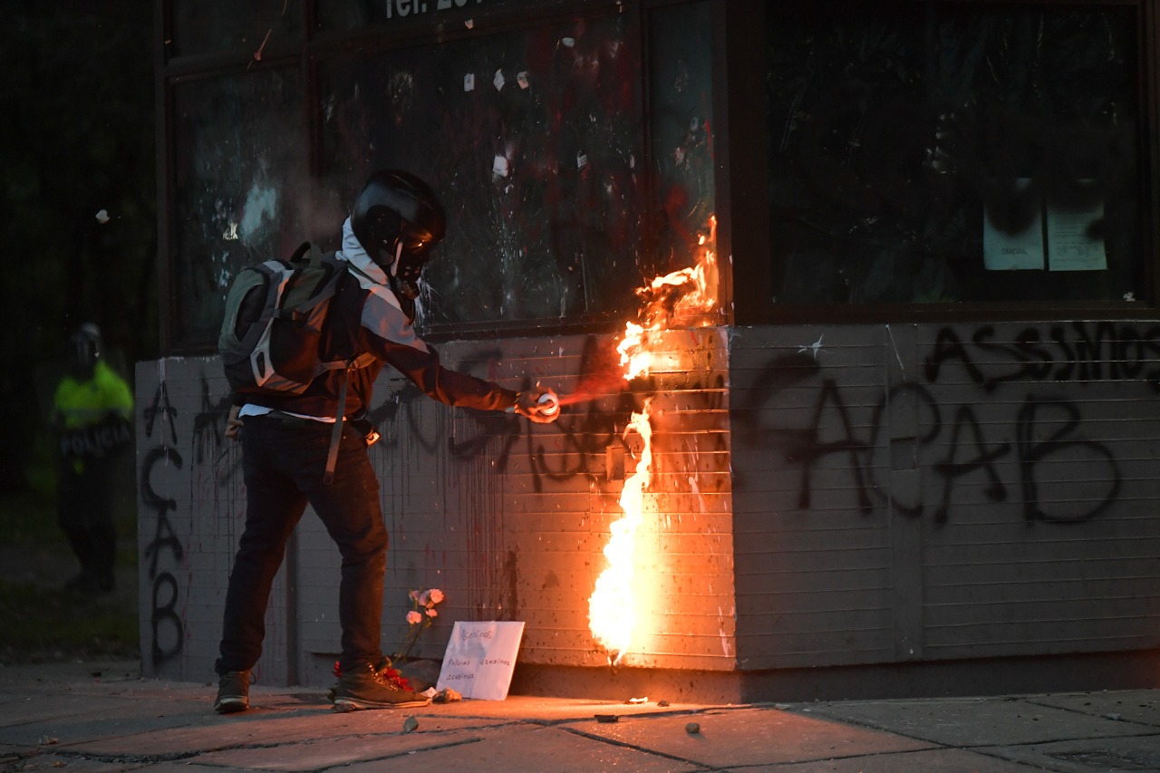 Un hombre intentando prender fuego en una ventana