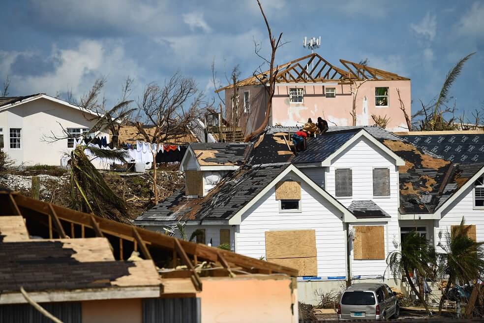 Residentes del barrio Marsh Harbour, en Gran Ábaco, uno de los lugares más afectados por el paso de Dorian, trabajan en el techo de una de las viviendas.  / AFP