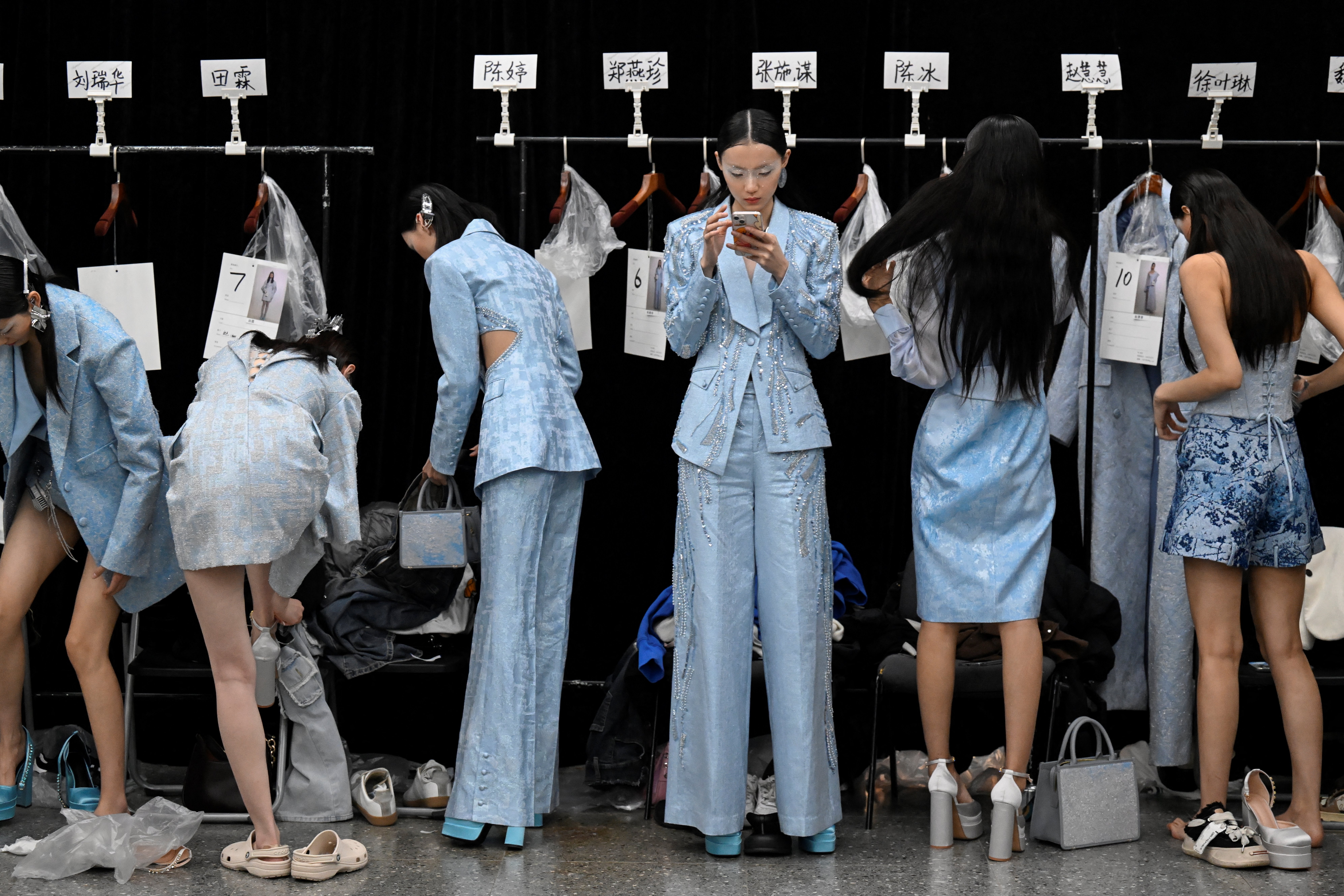 Modelos se preparan entre bastidores antes de una creación de Saint Joy de Bian Huizhong durante la Semana de la Moda de China, en Beijing.