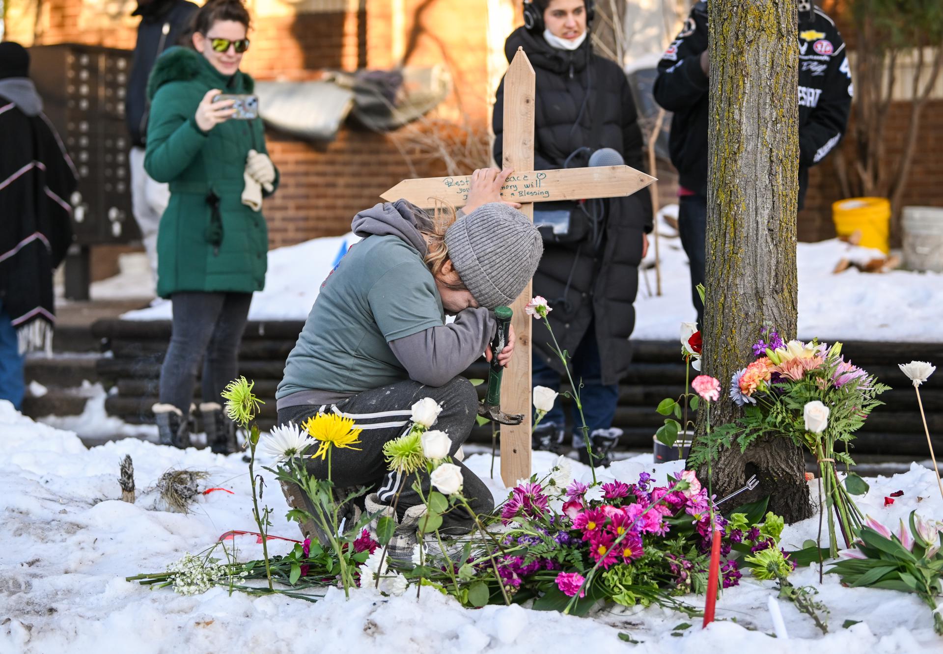 MINNEAPOLIS (United States), 08/01/2026.- A woman takes a moment as she places a cross at a makeshift memorial at the scene in which a woman was shot and killed by an Immigration and Customs Enforcement (ICE) agent in Minneapolis, Minnesota, USA, 07 January 2026. An ICE officer shot and killed a woman who was driving a car and blocking federal agents as they conducted immigration operations in South Minneapolis. EFE/EPA/CRAIG LASSIG