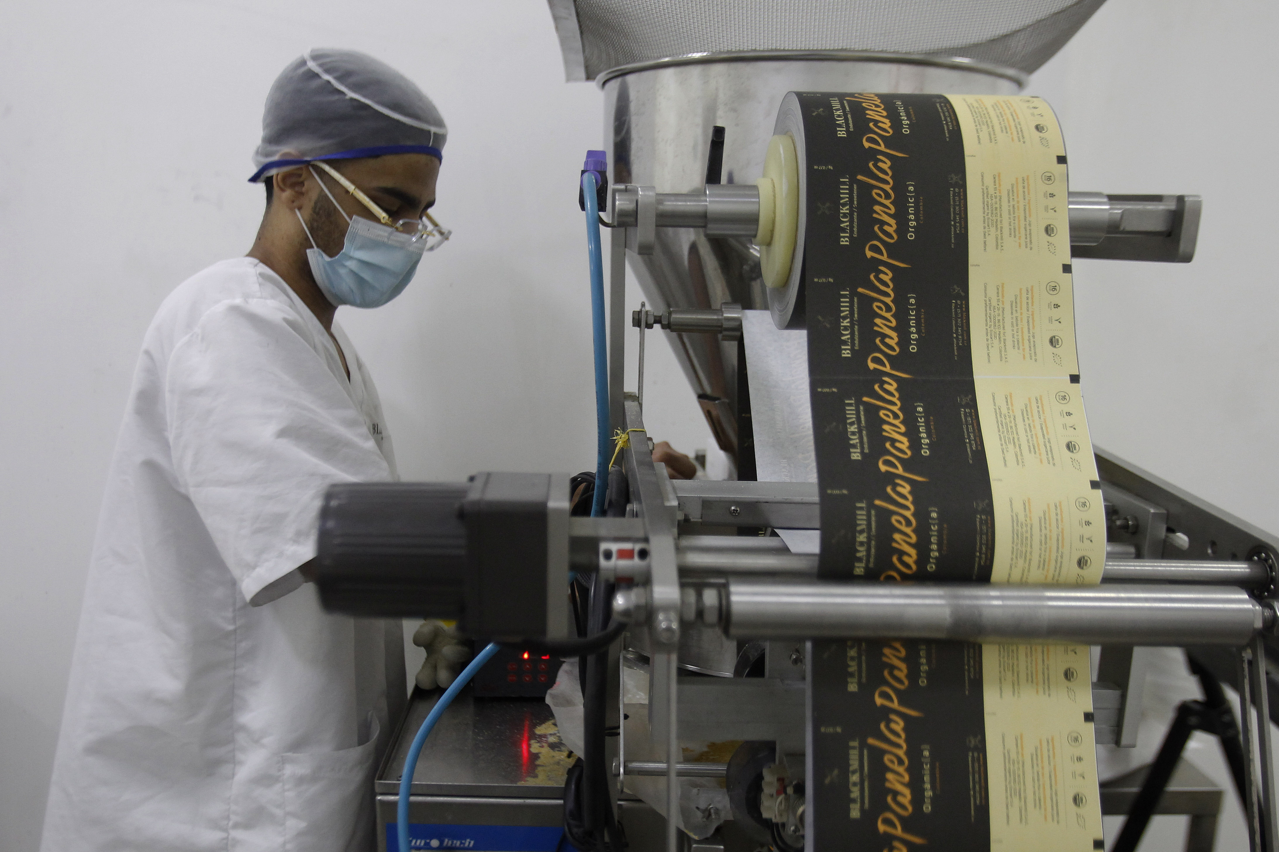 MED108. MEDELLÍN (COLOMBIA), 05/04/2023.- Un trabajador empaca panela en polvo en la empresa Blackmill, el 28 de marzo de 2023, en Medellín (Colombia). La panela que producen 50 familias campesinas e indígenas en Colombia termina en la mesa de alemanes y estadounidenses como resultado de la aventura que emprendieron hace cinco años dos jóvenes de Medellín interesados en transformar este producto autóctono para llevarlo a otros públicos. EFE/ Luis Eduardo Noriega A.