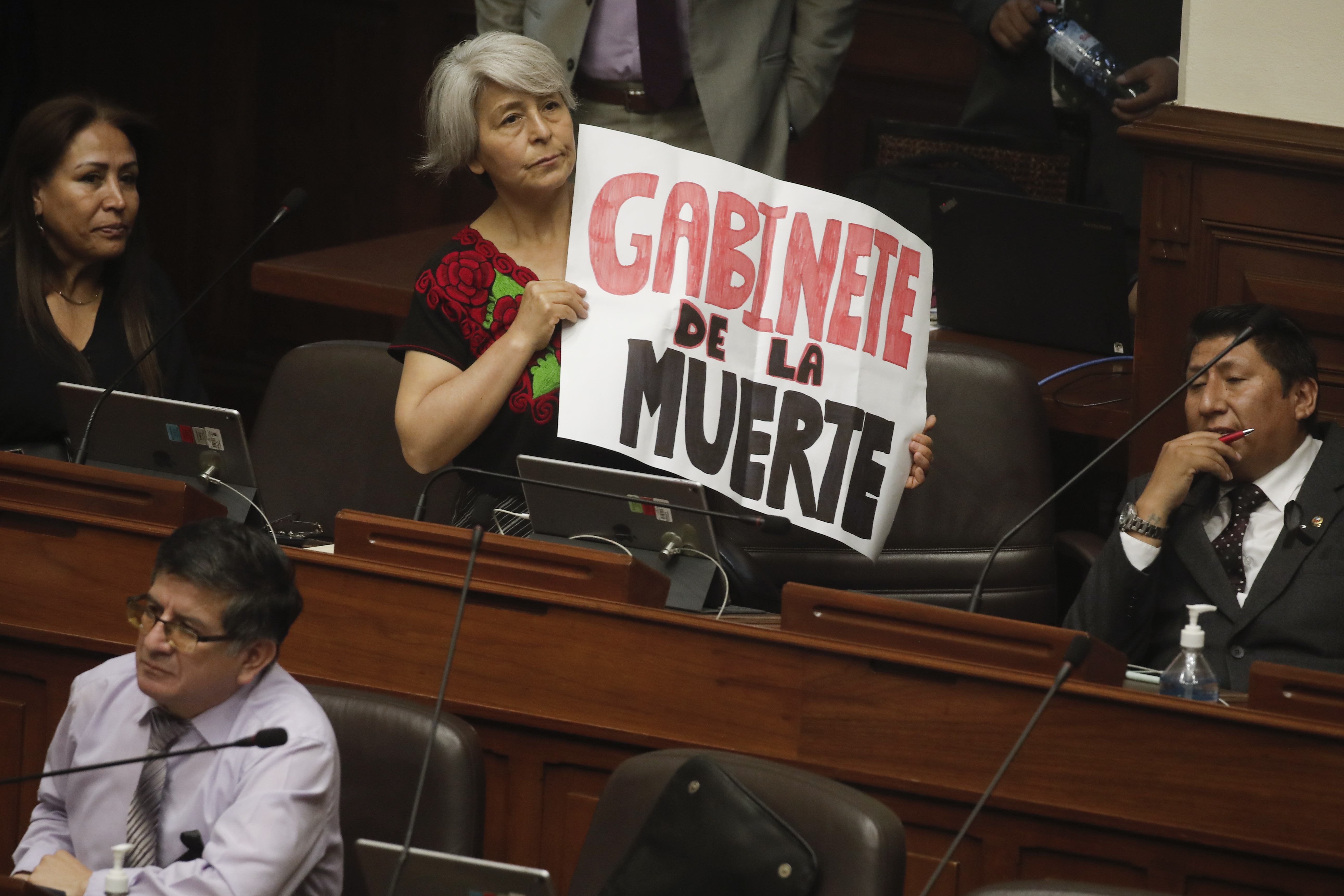 AME5304. LIMA (PERU), 10/01/2023.- La congresista de Perú Libre, Margot Agüero, muestra un cartel que dice "Gabinete de la muerte" mientras el primer ministro de Perú, Alberto Otarola, y su gabinete enfrentan un voto de confianza, en el Congreso, hoy en Lima (Perú). El primer ministro de Perú, Alberto Otárola, quien encabeza el segundo gabinete del Gobierno de Dina Boluarte, llegó este martes al Congreso para pedir el voto de confianza del Parlamento, un proceso obligatorio que deben pasar tras el nombramiento, en medio de la escalada de violencia en el sur del país por protestas antigubernamentales que el lunes dejaron un saldo de 17 fallecidos. EFE/Sebastian Castaneda/Pool