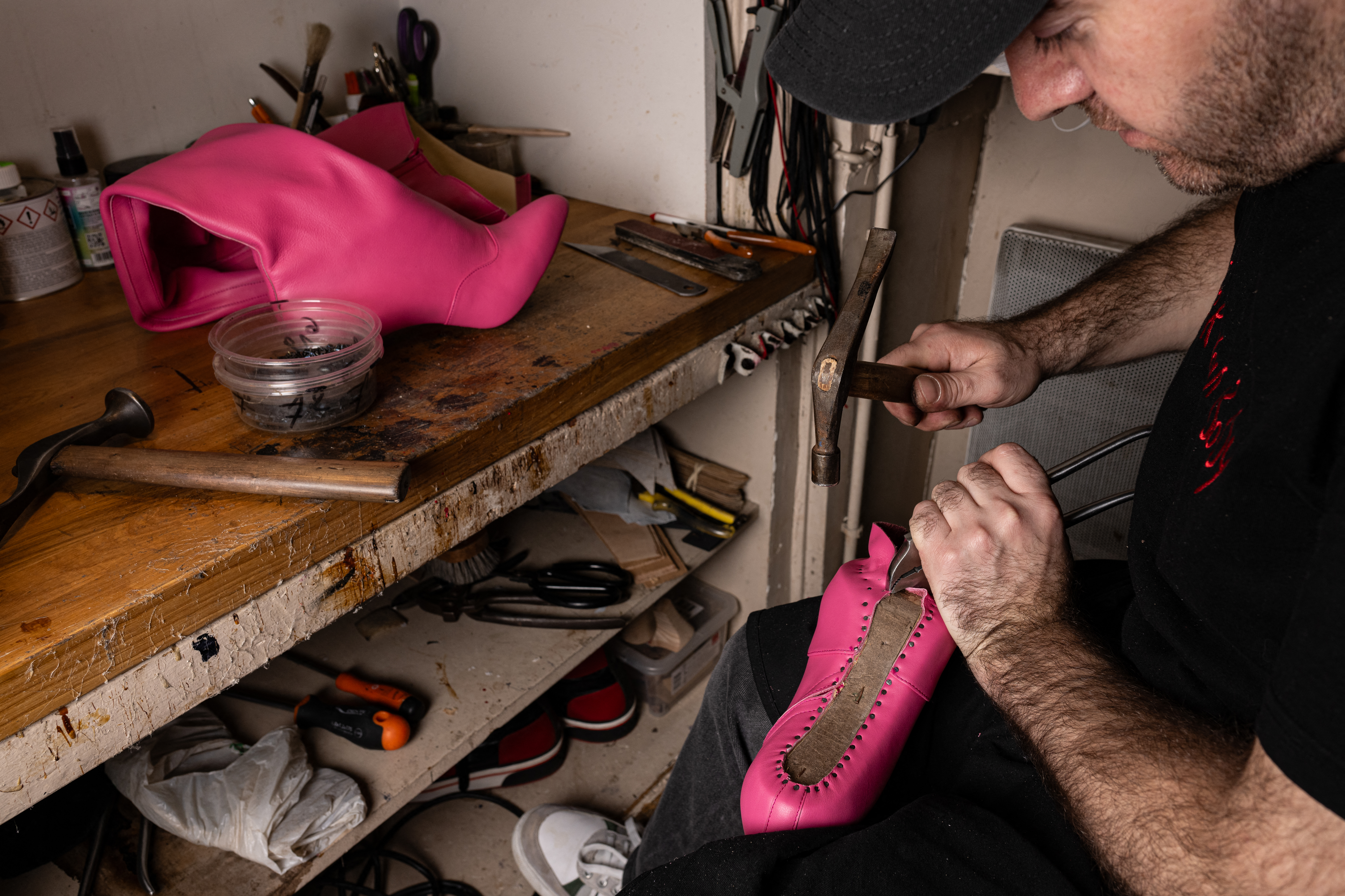 A bootmaker works on a boot for dancers of the Moulin Rouge musical cabaret at the Clairvoy house atelier in Paris on March 12, 2024. (Photo by Miguel MEDINA / AFP)
