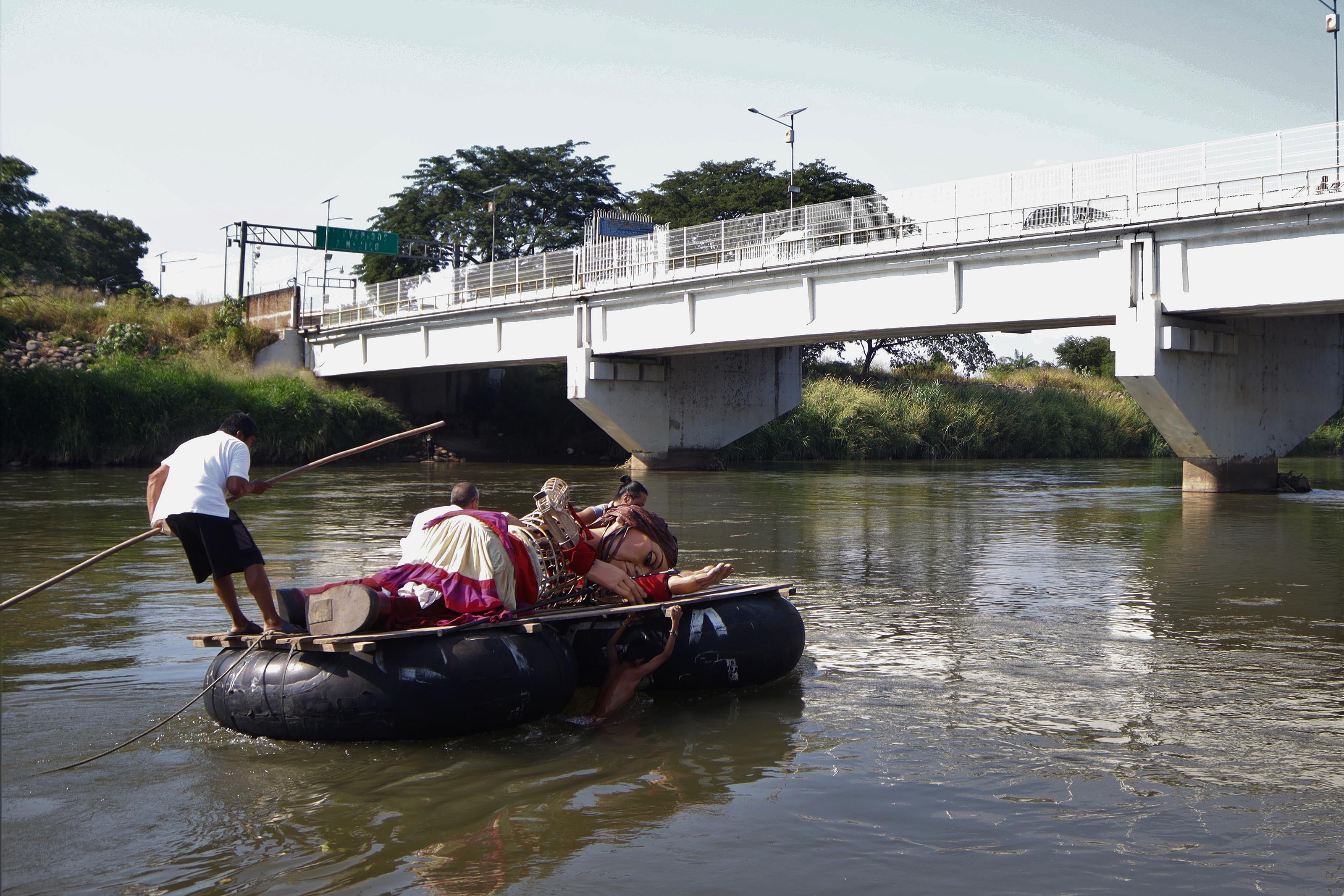 MEX2892. CIUDAD HIDALGO (MÉXICO), 26/11/2023.- La marioneta Amal, que representa a una niña migrante siria, cruza hoy el río Suchiate en una balsa en Ciudad Hidalgo, estado de Chiapas (México). La pequeña Amal, la muñeca de tres metros que representa a una niña siria refugiada, llegó este domingo a Ciudad Hidalgo, frontera de México con Guatemala, la última ciudad de América y la puerta de entrada de miles de migrantes que intentan llegar a los Estados Unidos. EFE/Juan Manuel Blanco