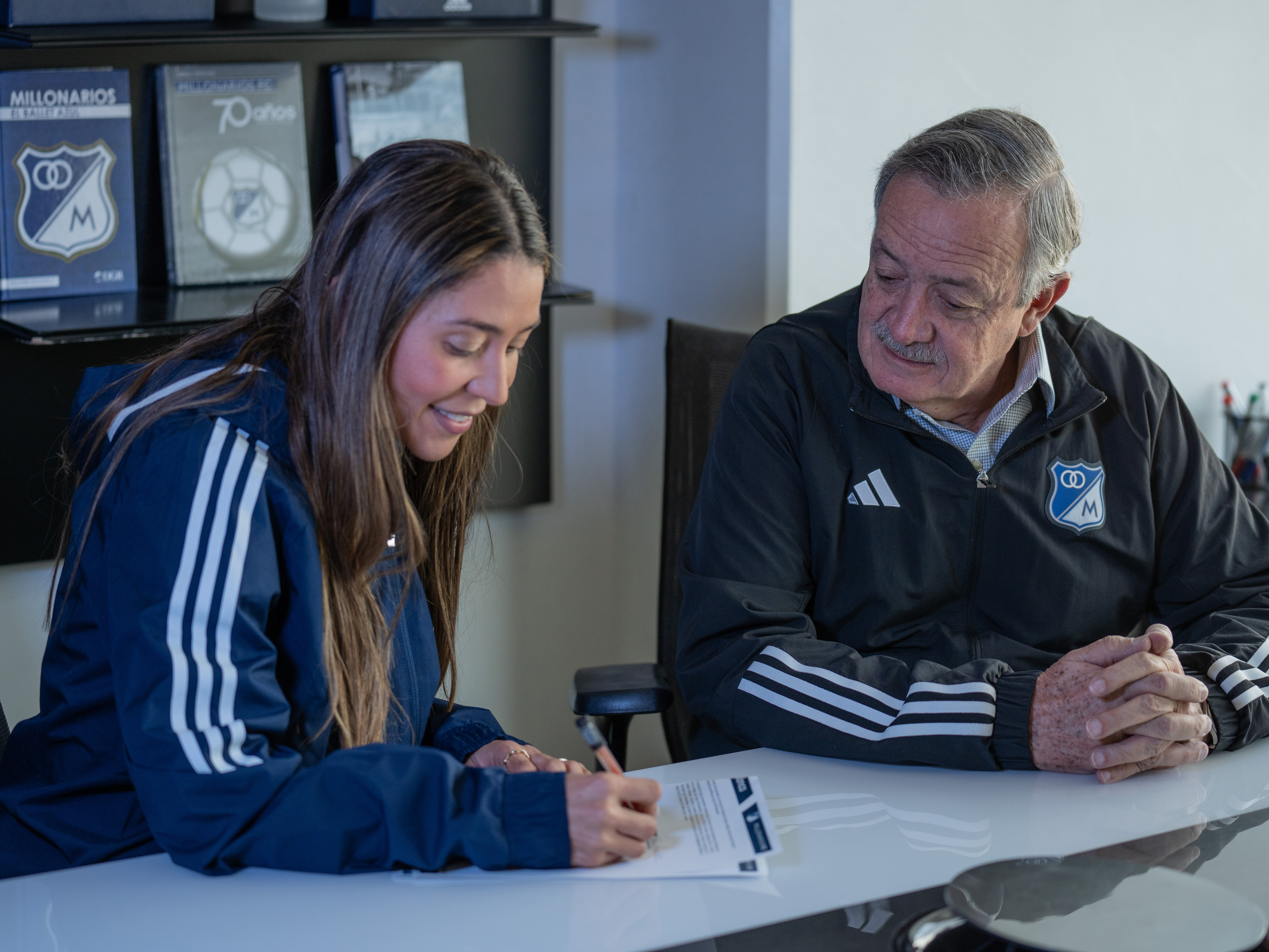 Angie Vega con Enrique Camacho, presidente de Millonarios, firmando su contrato como entrenadora de Millonarios Femenino.