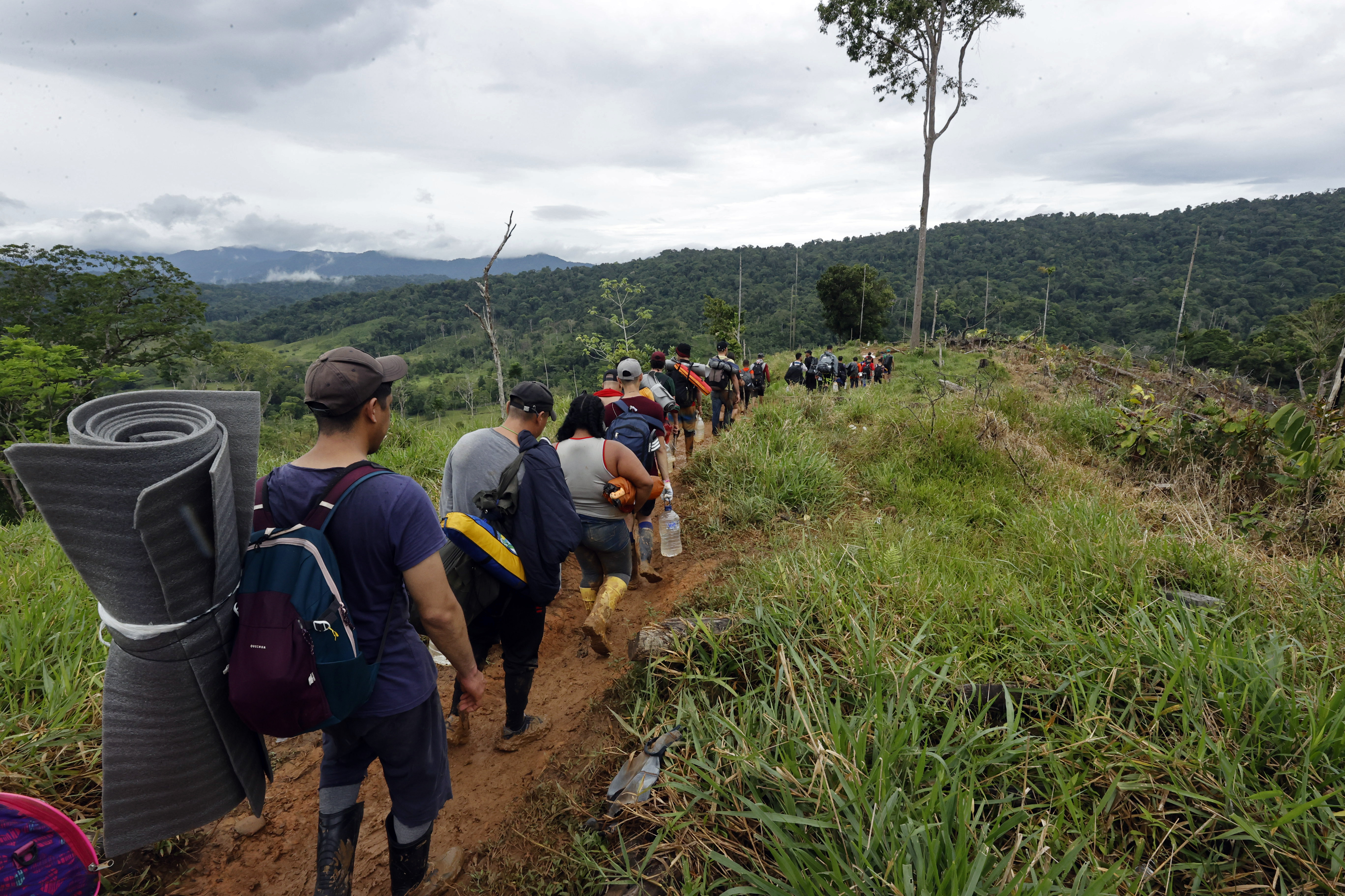 ACOMPAÑA CRÓNICA: CRISIS MIGRATORIA***AME3342. TAPÓN DEL DARIÉN (COLOMBIA), 10/10/2022.- Migrantes venezolanos suben una montaña con la intención de llegar a Panamá, el 8 de octubre de 2022 en el Tapón del Darién (Colombia). Cuando José Juan le dijo a Steven que quería ir a EE.UU. por el Darién, su hijo de 7 años le dijo que eso era peligroso, que era mejor hacerlo en avión, pero aún así ahora lidera enérgico el grupo de migrantes que comienza su travesía por esta inhóspita selva que separa a Colombia de Panamá. Como ellos, más de 150.000 personas -el 60 % de ellos venezolanos- han decidido cruzar en lo que va de año por uno de los pasos migratorios más peligrosos del mundo, una travesía que puede durar la semana por una selva montañosa donde no hay ley. EFE/Mauricio Dueñas Castañeda