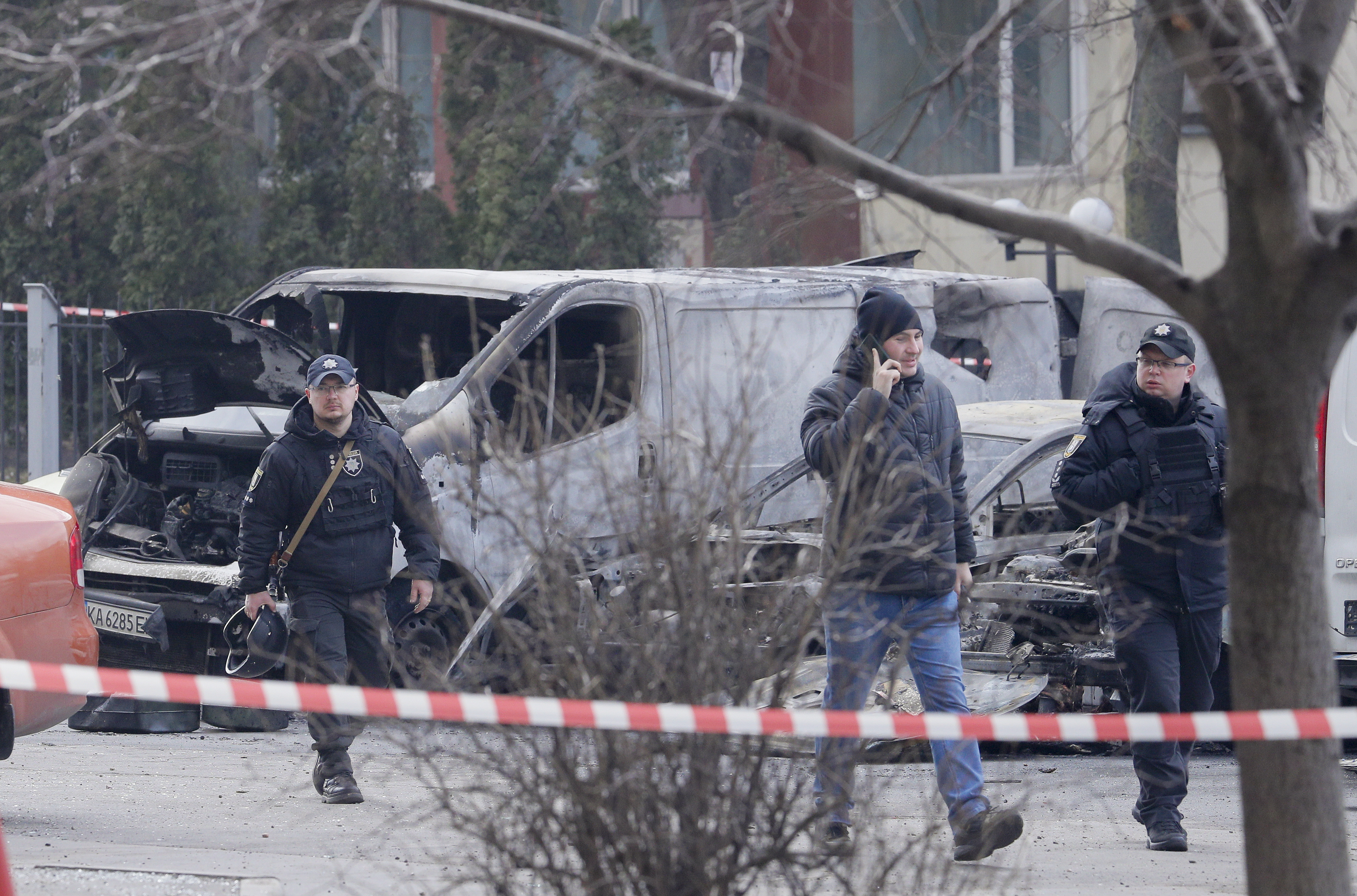 Kyiv (Ukraine), 09/03/2023.- Policemen walk past burned cars at a residential area hit by falling debris from a rocket, in Kyiv (Kiev), Ukraine, 09 March 2023, amid Russia's invasion. Ukrainian authorities said on 09 March that Russia fired 81 missiles across the country targeting critical infrastructure and residential buildings. The country's Defense Ministry confirmed that 34 cruise missiles were shot down. According to Ukraine's nuclear operator Energoatom, the Zaporizhzhia nuclear power plant (NPP) lost power as a result of the missile attacks, and was running on diesel generators. (Atentado, Incendio, Rusia, Ucrania) EFE/EPA/SERGEY DOLZHENKO