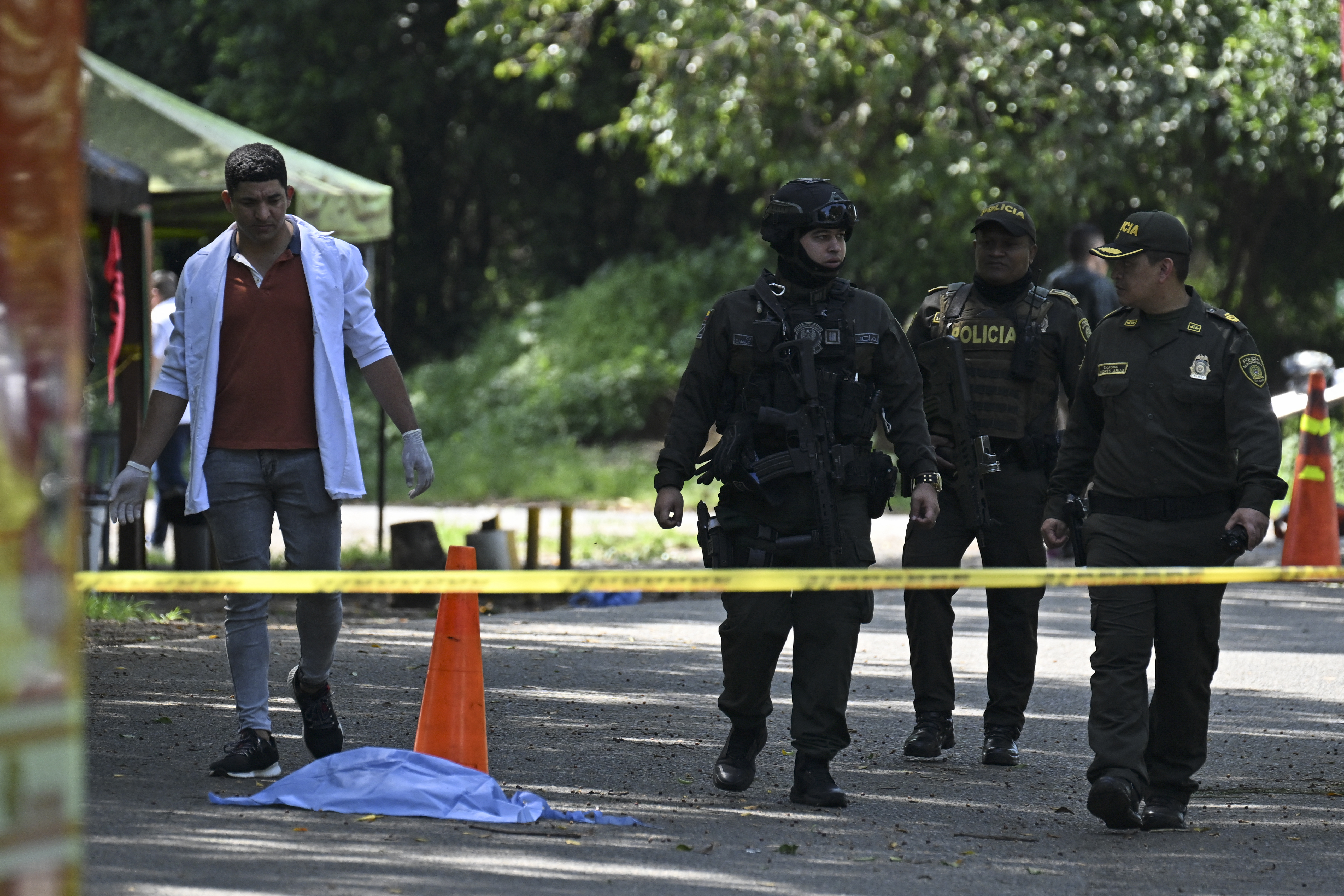 Colombian policemen and forensic experts work at the site where a motorcycle bomb exploded in Jamundi, Valle del Cauca, Colombia, on December 7, 2024, which left one dead and seven civilians and seven policemen injured, according to authorities.