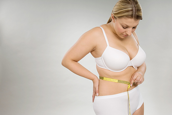 A woman measuring her waist