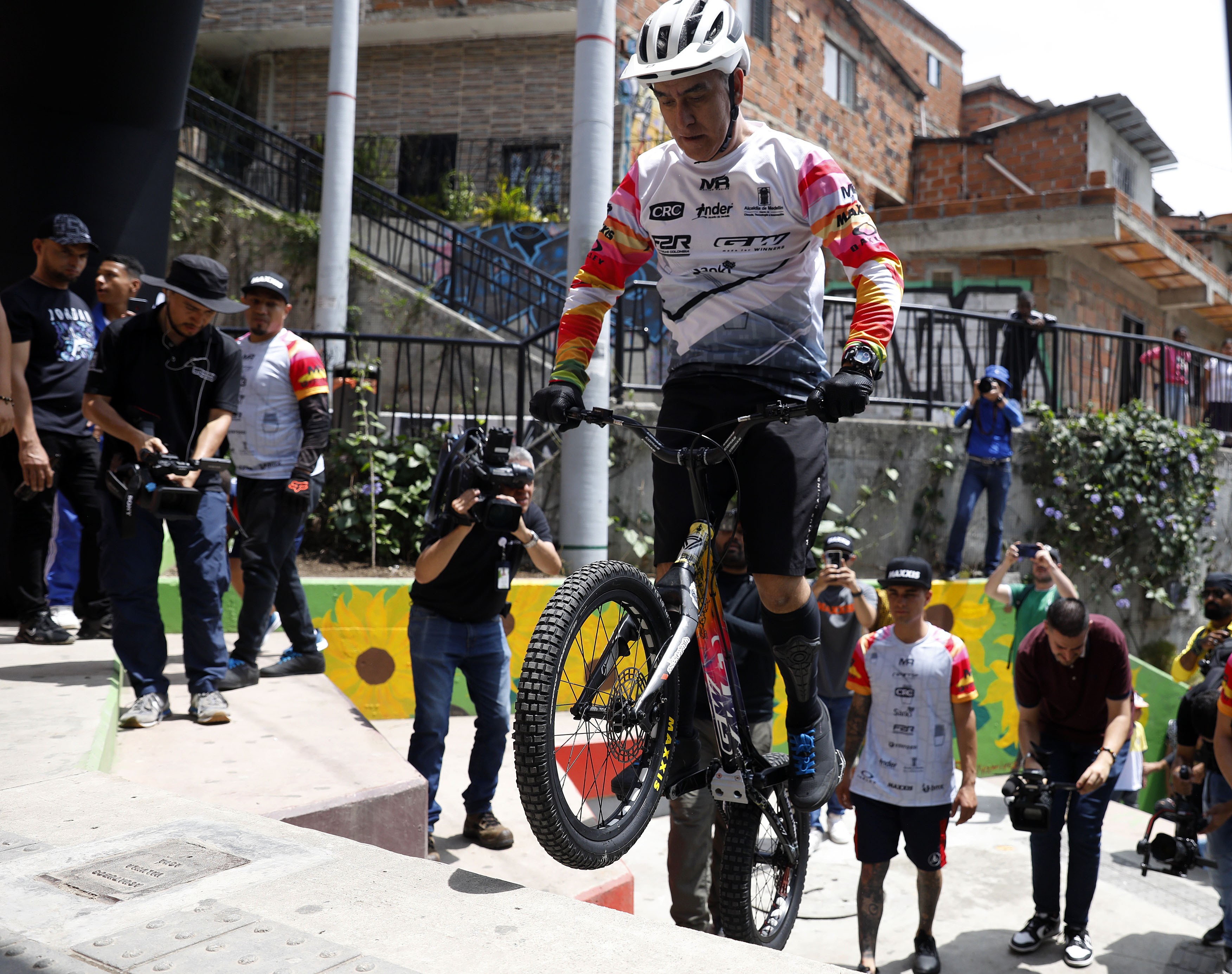 AME1001. MEDELLÍN (COLOMBIA), 27/04/2024.- El deportista extremo colombiano Javier Zapata, cinco veces Récord Guinness de Biketrial, realiza el "Reto escaleras Comuna 13" de subir 223 escalones de la Comuna 13 este sábado, en Medellín (Colombia). EFE/Luis Eduardo Noriega Arboleda