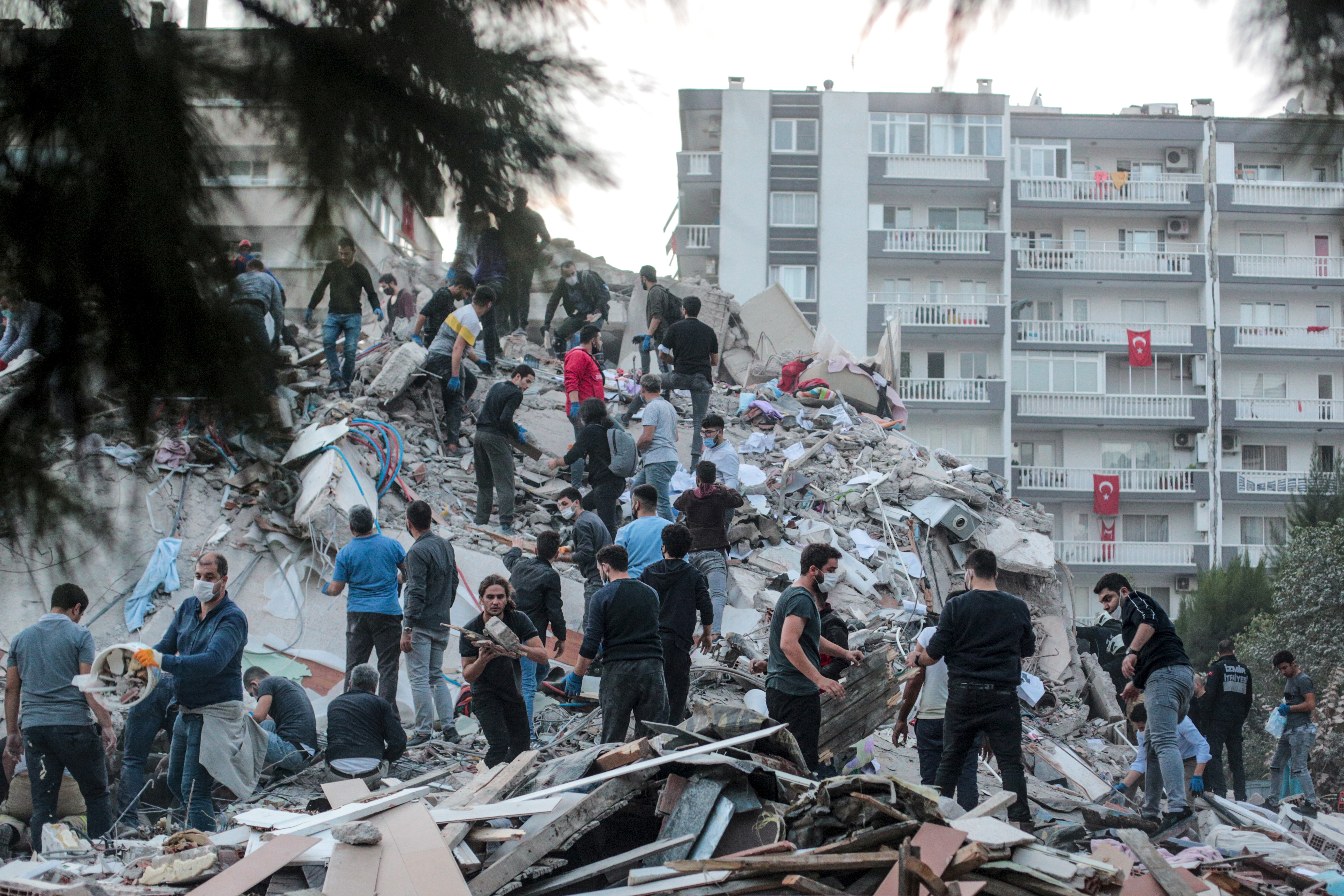 Voluntarios limpian los escombros en mientras buscan sobrevivientes en un edificio derrumbado después de que un fuerte terremoto sacudiera la costa occidental del país y partes de Grecia, matando a cuatro personas e hiriendo a 120, en Izmir, el 30 de octubre de 2020