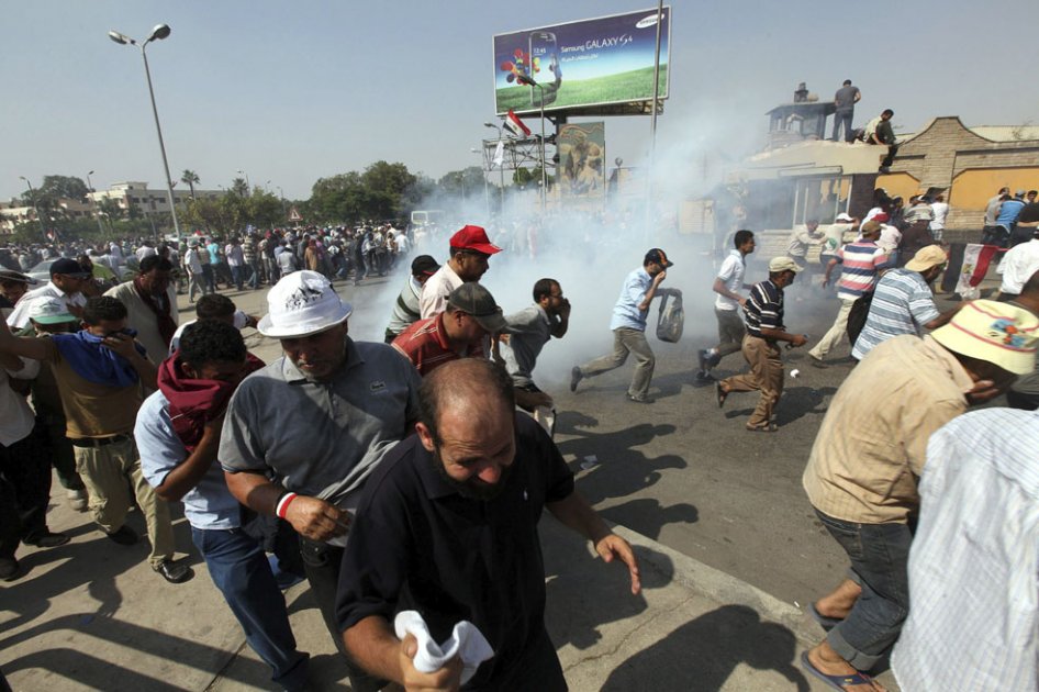 Simpatizantes del presidente depuesto Mohamed Mursi corren para ponerse a salvo durante los enfrentamientos entre manifestantes y soldados egipcios frente a la sede de la Guardia Republicana en El Cairo./ EFE