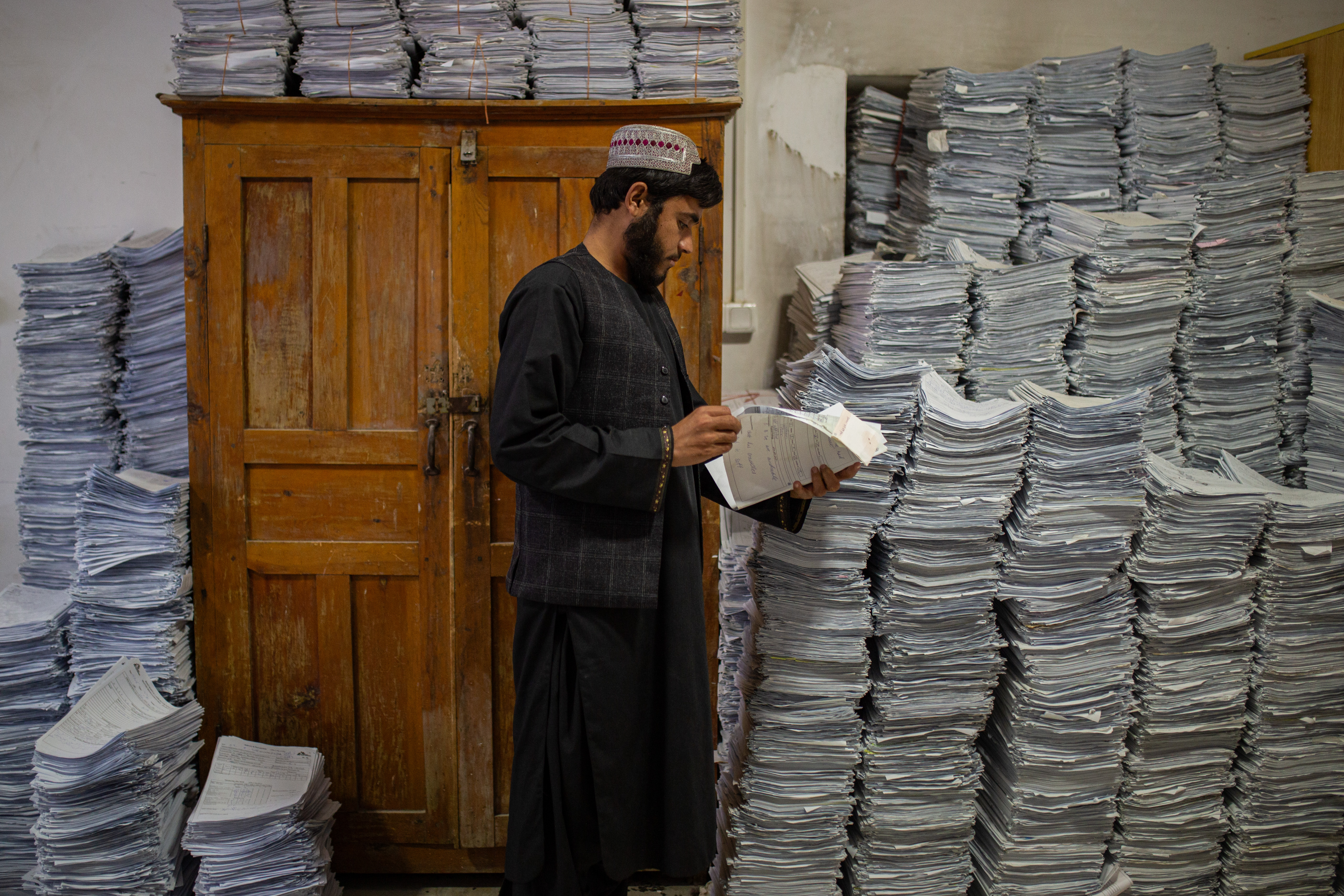 En el hospital provincial Boost, apoyado por MSF, un miembro del personal consulta un archivo en una sala llena de información médica y registros de pacientes, ordenados por fecha. Lashkar Gah, provincia de Helmand, Afganistán, septiembre de 2025.