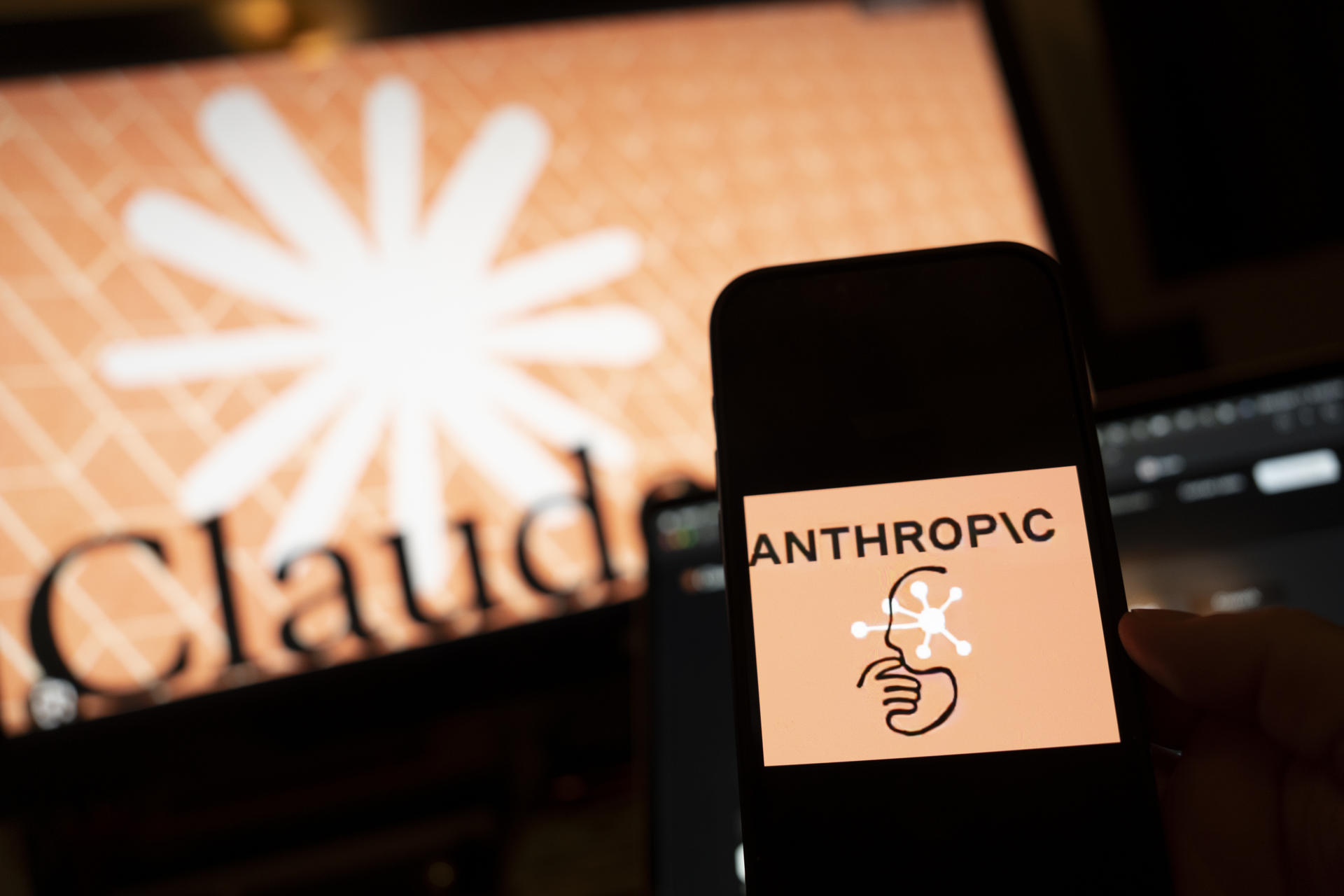 AME3167. NUEVA YORK (ESTADOS UNIDOS), 12/03/2026.- Una persona sostiene un teléfono con el logotipo de la inteligencia artificial (IA) Anthropic este miércoles, en Nueva York (Estados Unidos). La creciente disputa legal y ética entre las tecnológicas y el Pentágono está reconfigurando el tablero de la IA: Anthropic ha visto crecer su popularidad entre los civiles a la par que se enfrenta en los tribunales a la Administración de Donald Trump; OpenAI enfrenta críticas por su cercanía al sector militar; y Google expande discretamente su presencia en Defensa. EFE/ Angel Colmenares