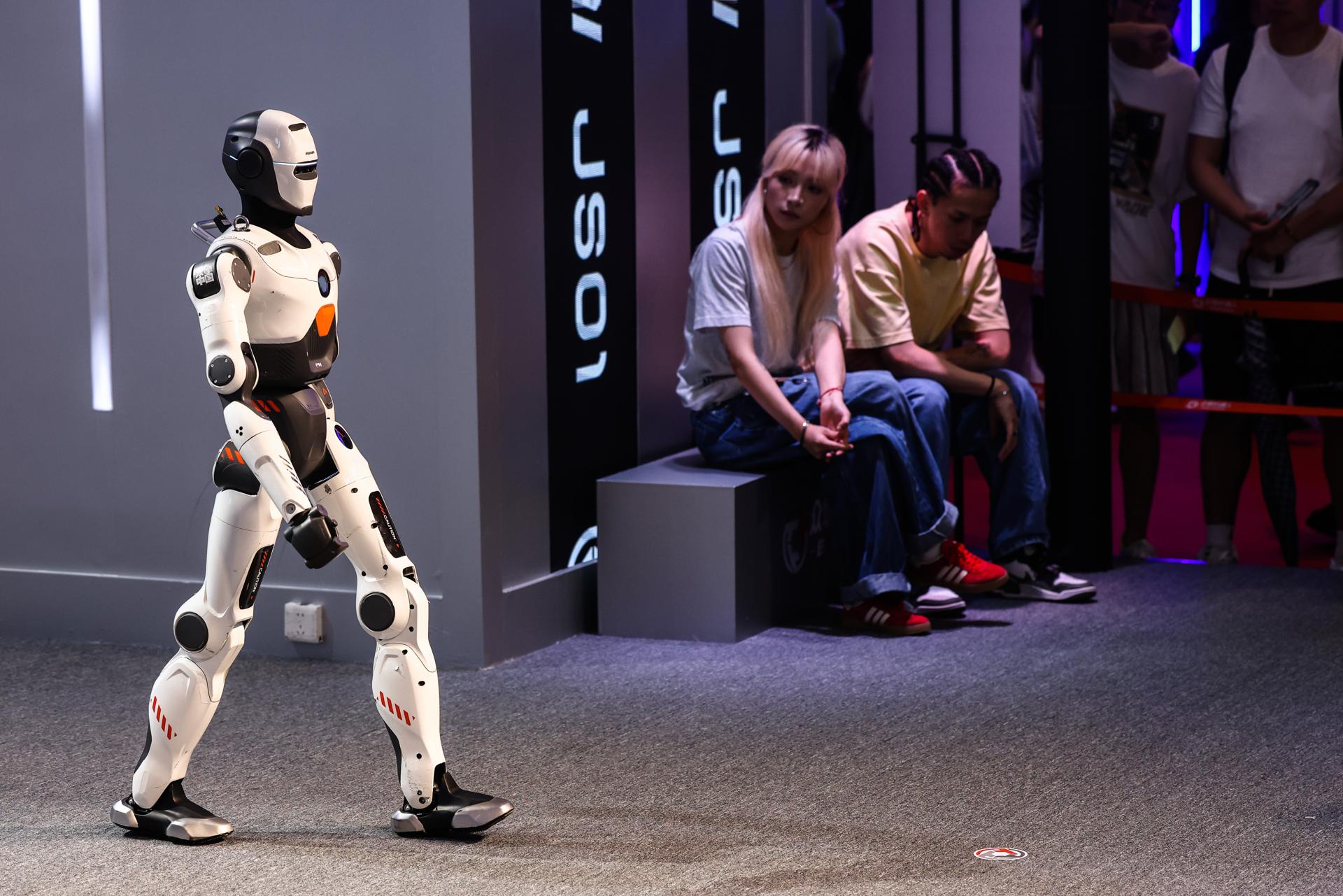 BEIJING (China), 08/08/2025.- People look at a humanoid robot during the 2025 World Robot Conference (WRC) at Etrong International Exhibition and Convention Center in Beijing, China, 08 August 2025. The conference will take place from 08 to 12 August 2025. EFE/EPA/WU HAO